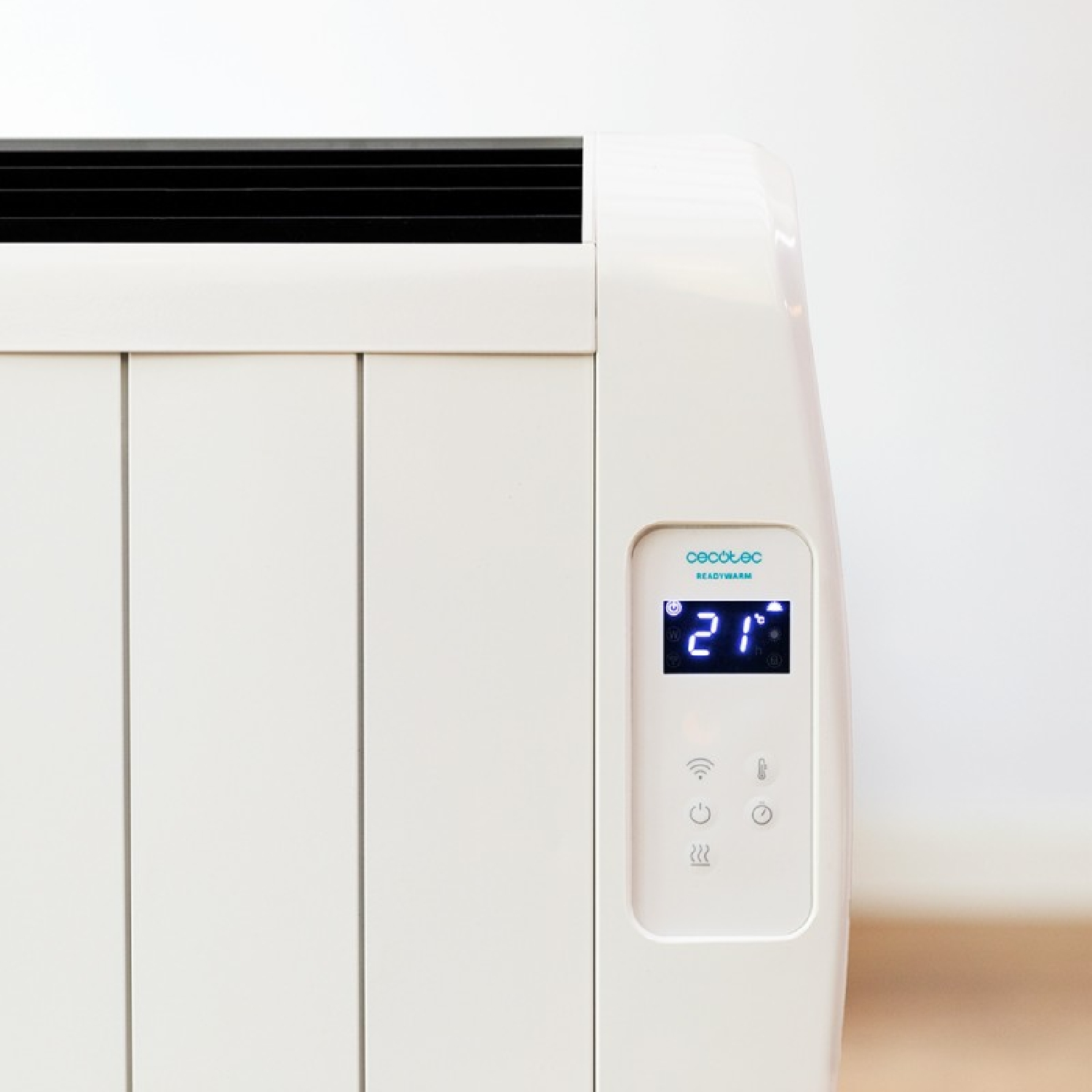Biały grzejnik elektryczny z cyfrowym wyświetlaczem pokazującym 21. Białe tło.