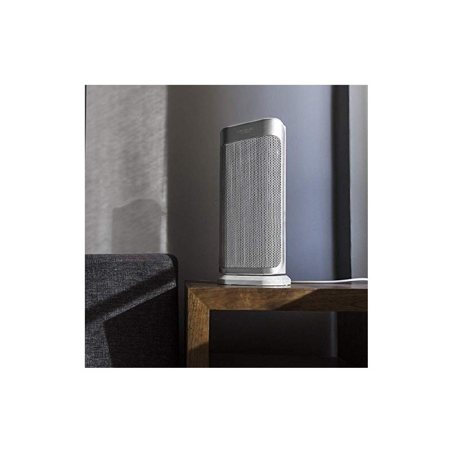 Srebrny grzejnik elektryczny na stole. Szare tło.