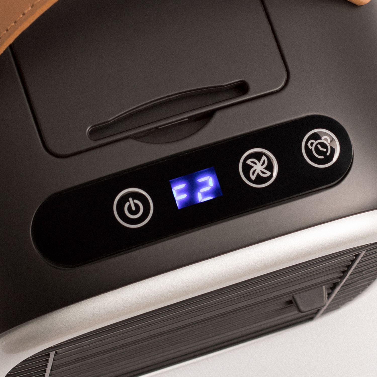 Un dispositivo negro con botones. La pantalla muestra 'F2'. Los botones tienen iconos.