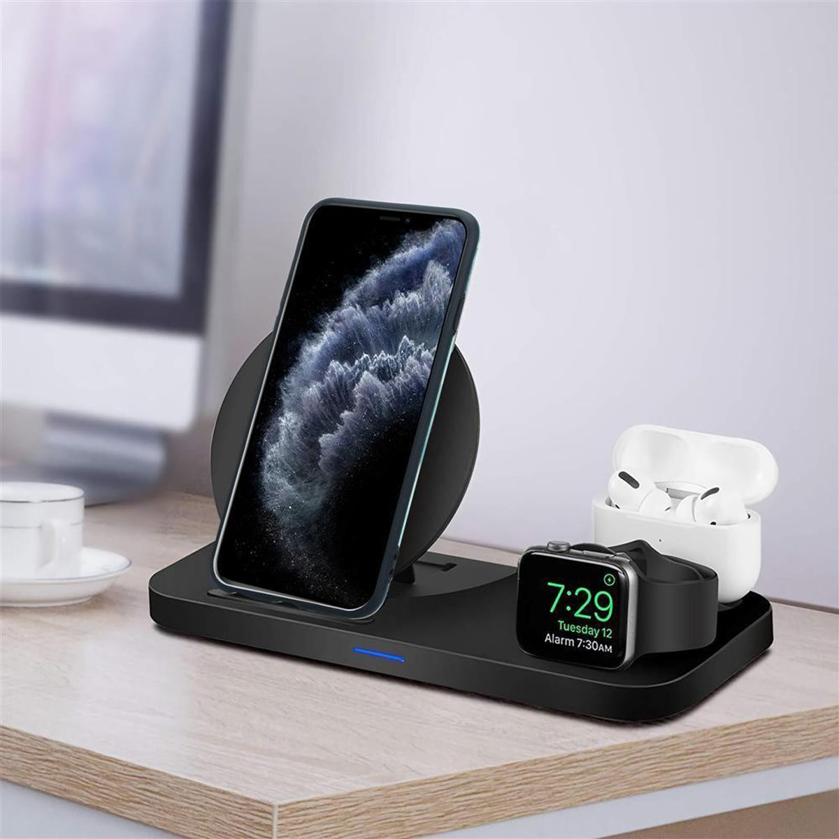 Una stazione di ricarica con telefono, smartwatch e auricolari. Il telefono è sul supporto, mostrando il suo schermo.