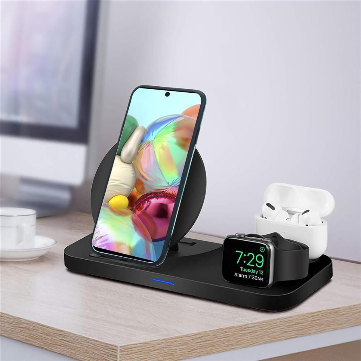 Una stazione di ricarica wireless con un telefono, auricolari e uno smartwatch. Sfondo bianco.