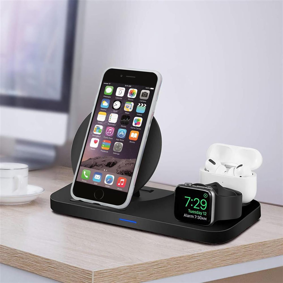 Kabellose Ladestation mit Telefon, AirPods und Smartwatch auf einem Holztisch.