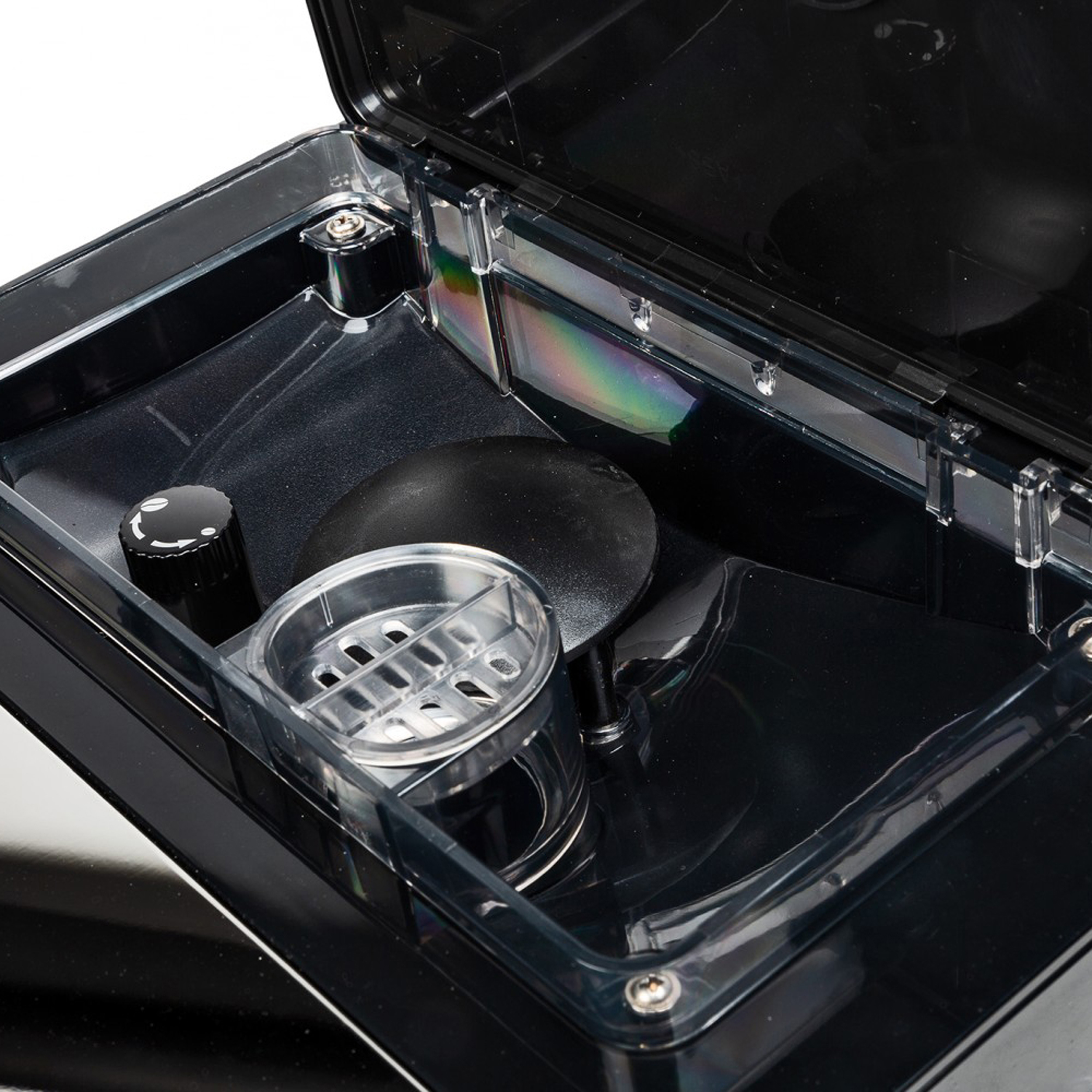 Eine offene schwarze Box mit Fächern. Im Inneren befinden sich schwarze und transparente Kunststoffbehälter mit einem schwarzen Knopf.