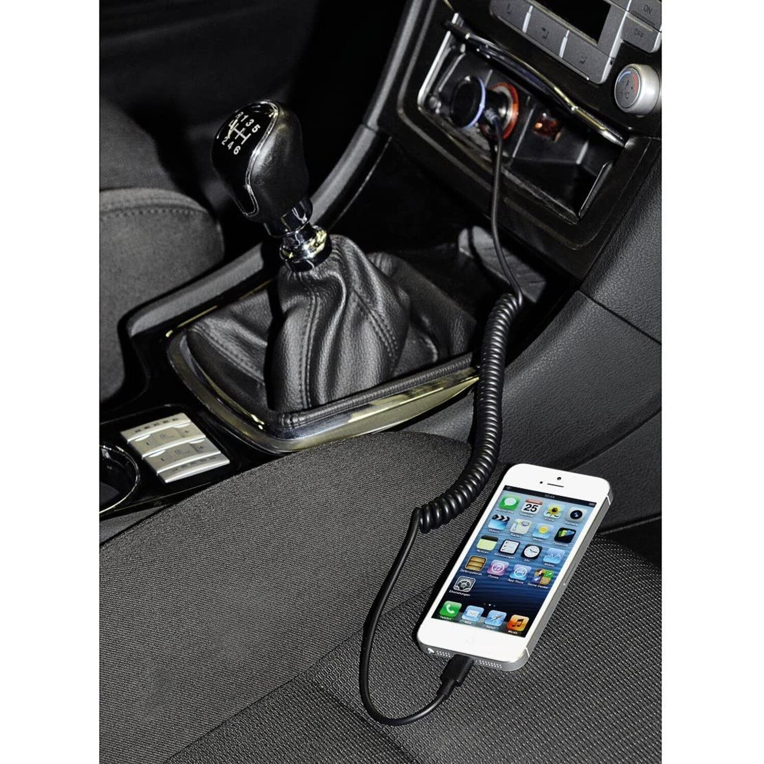 Ein weißes iPhone ist an den USB-Anschluss eines Autos angeschlossen. Schwarzer Innenraum.