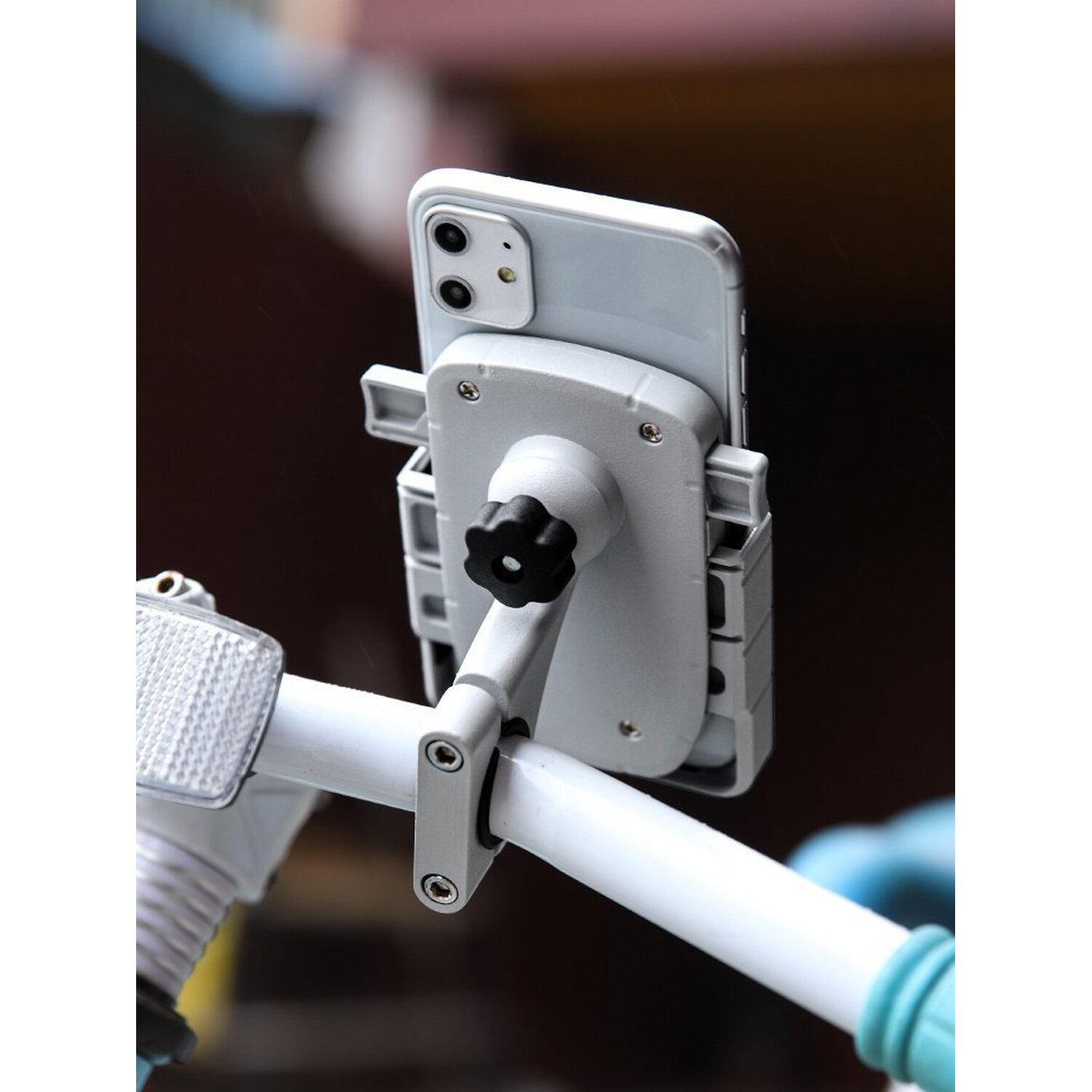 Ein Telefon, das mit einer Halterung an einem Fahrradlenker befestigt ist. Die Halterung ist grau und schwarz.