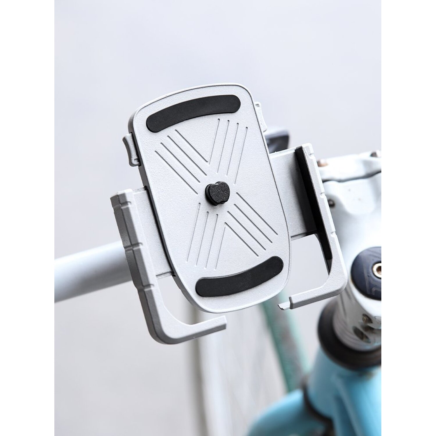 Silberner Telefonhalter an einem Fahrradlenker. Der Halter hat eine verstellbare Klemme für ein Telefon.