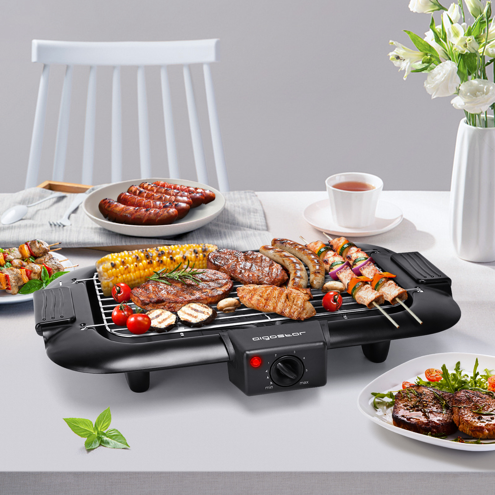 Elektrischer Grill mit verschiedenen gekochten Speisen und Zutaten. Die Szene spielt auf einem Tisch.