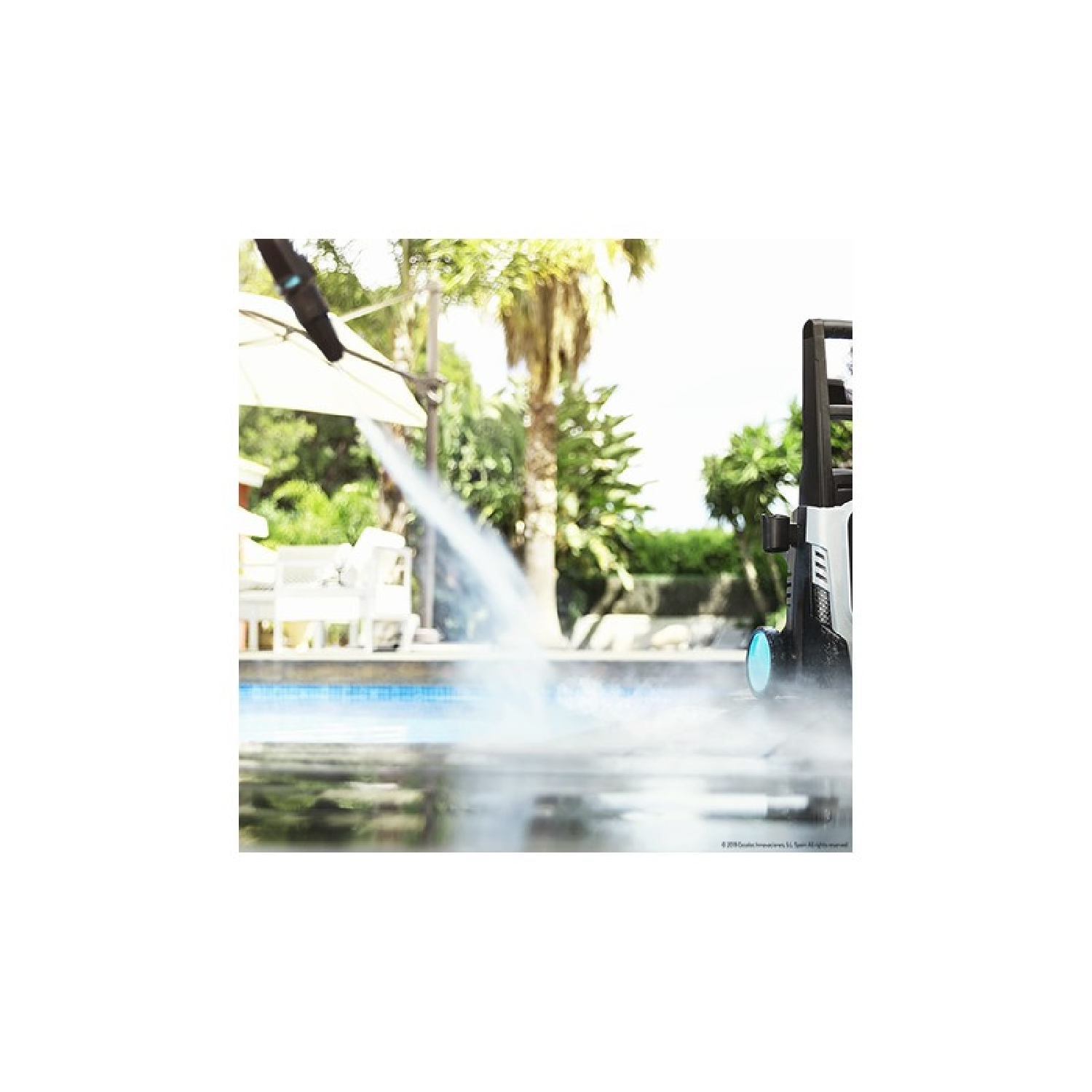 Una hidrolavadora rociando agua en una piscina. Se ven la piscina y un patio.