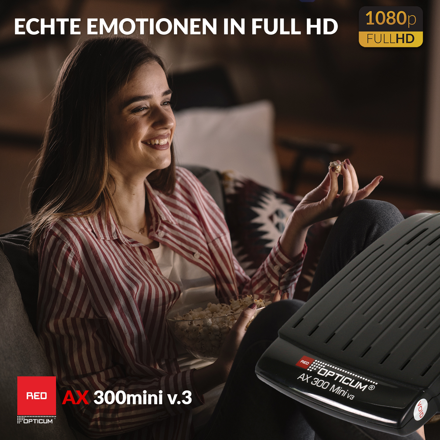 Eine Frau schaut fern, hält Popcorn, mit einem AX 300 mini v.3 Gerät und dem Wort 'Red' sichtbar.