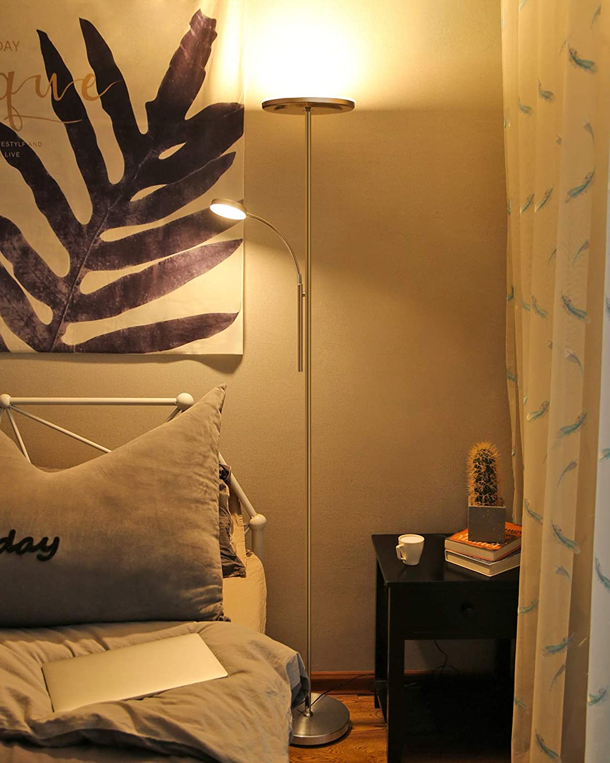 Schlafzimmer mit Stehlampe, Bett und Nachttisch. Lampe mit gebogenem Arm.