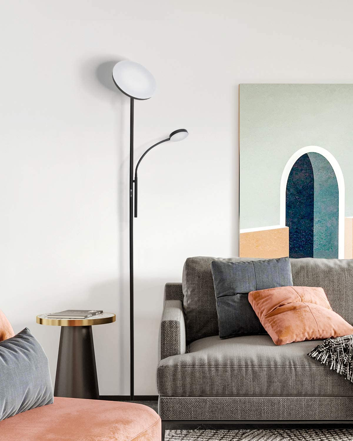Schwarze Stehlampe mit zwei Lichtern, neben Sofa und Beistelltisch mit Goldplatte.