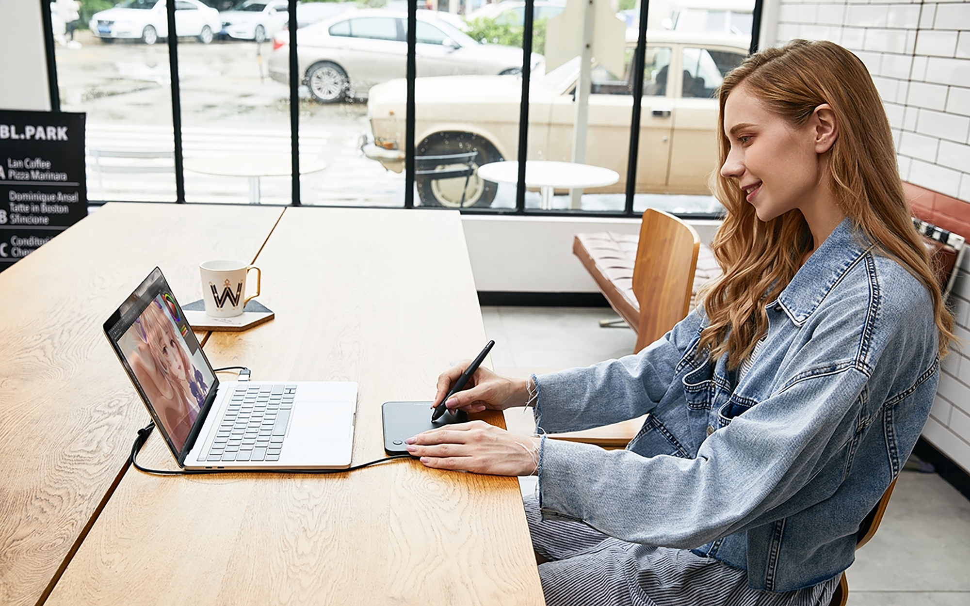 Kobieta używająca tabletu z rysikiem w kawiarni, pracująca nad projektem.