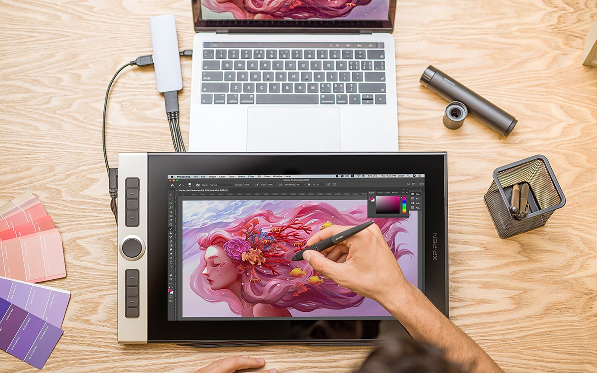 Espacio de trabajo de un artista, con una tableta de dibujo, un portátil y materiales de arte sobre una superficie de madera.