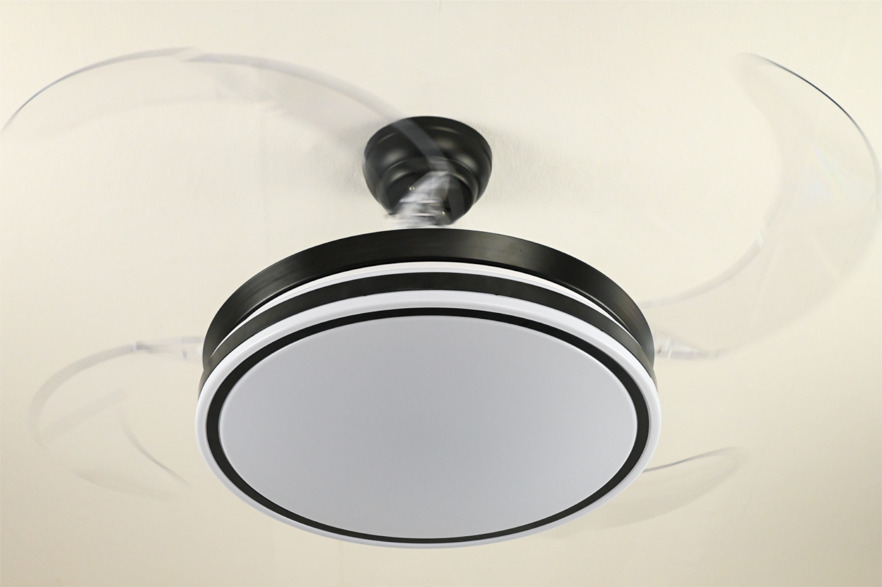 Ein Deckenventilator mit vier Flügeln und einem Licht. Kreisförmiges Design mit weißen und schwarzen Farben.