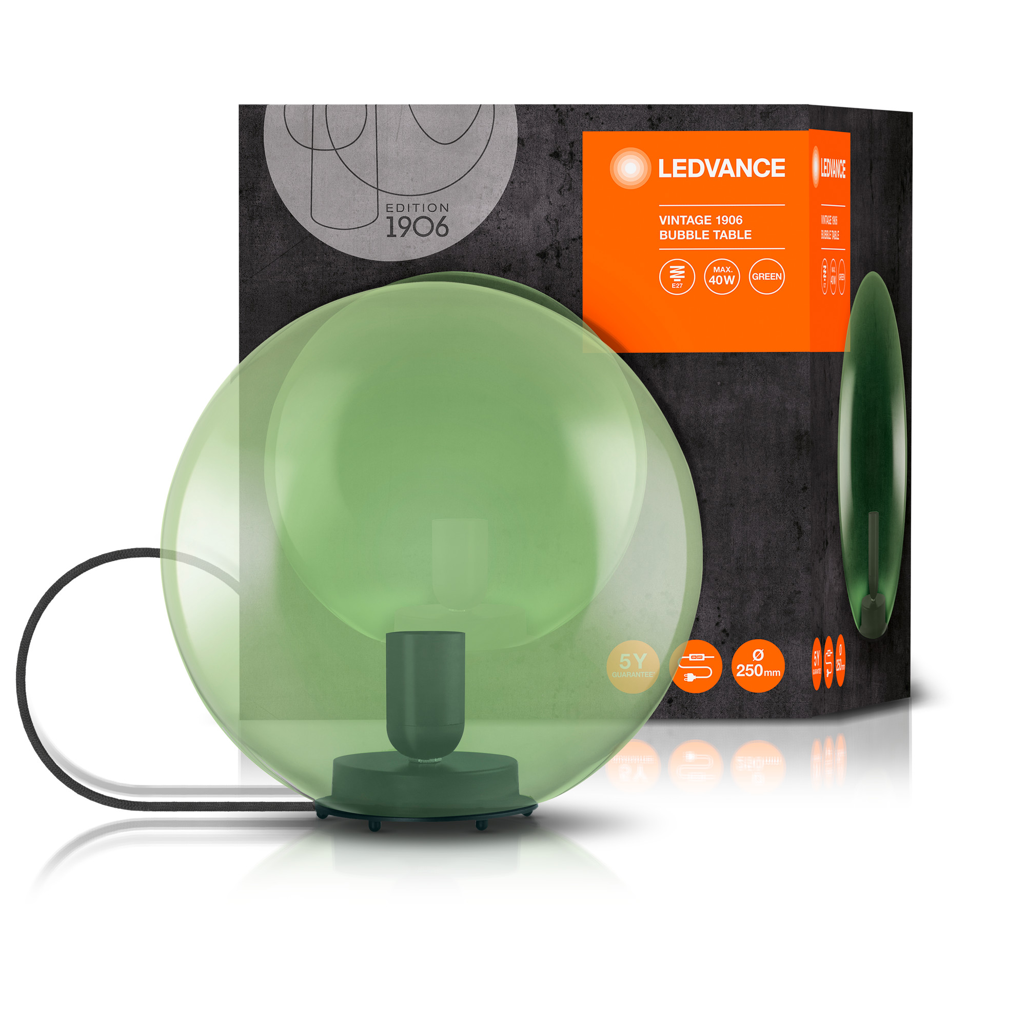 Zielona szklana lampa stołowa z żarówką w środku. Pudełko z tekstem i dodatkowa zielona lampa.