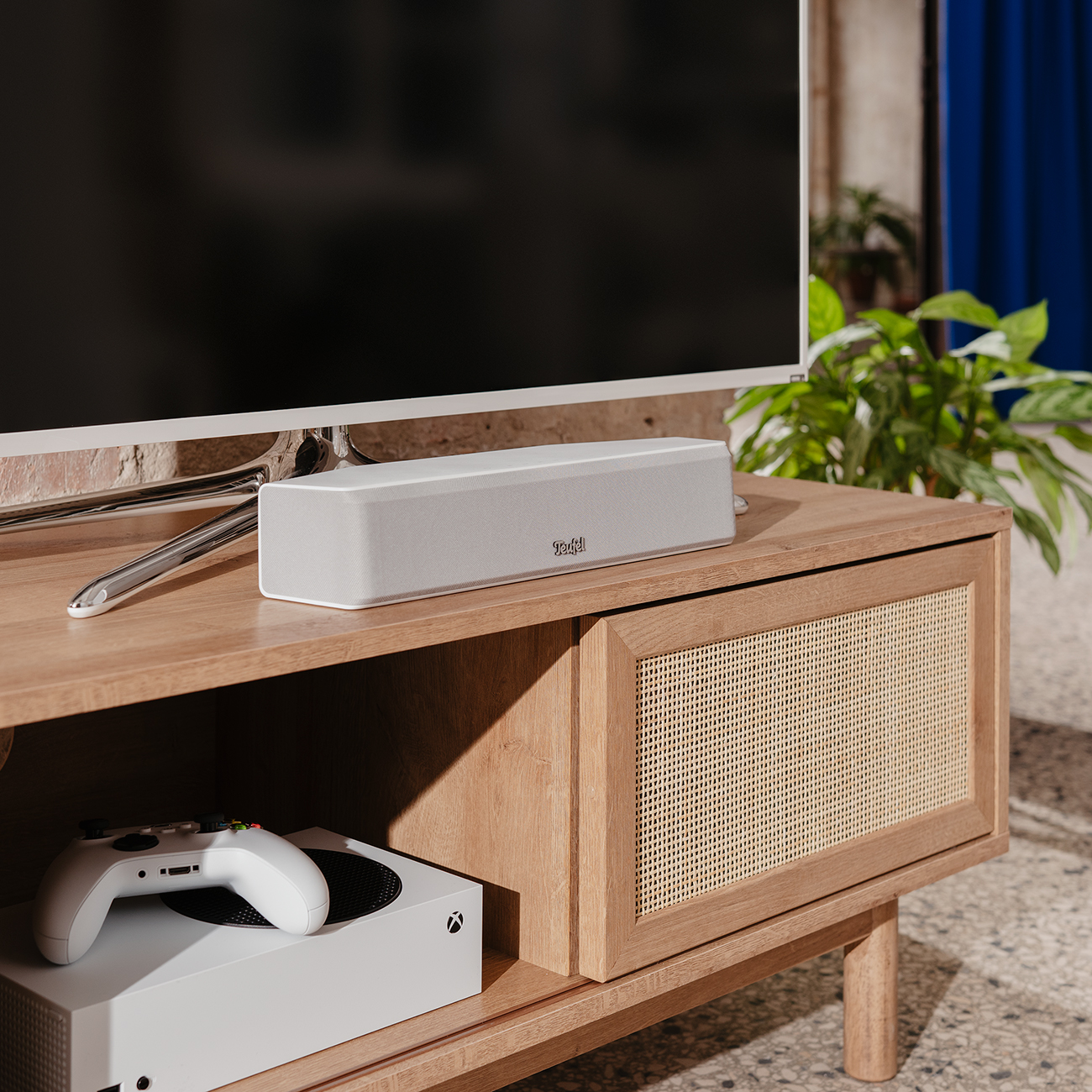 Entertainmentopstelling: tv, soundbar, console en controller.