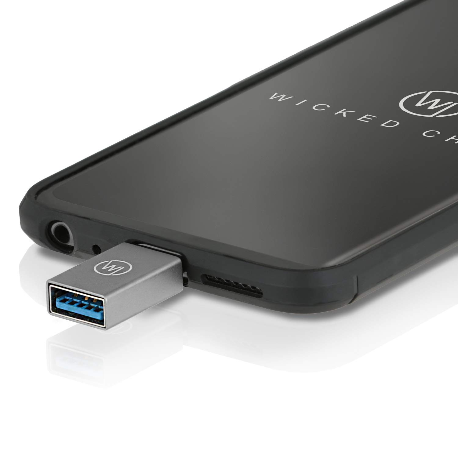 Ein silberner USB-C-Adapter, der in ein schwarzes Telefon eingesteckt ist, abgewinkelt vor weißem Hintergrund.