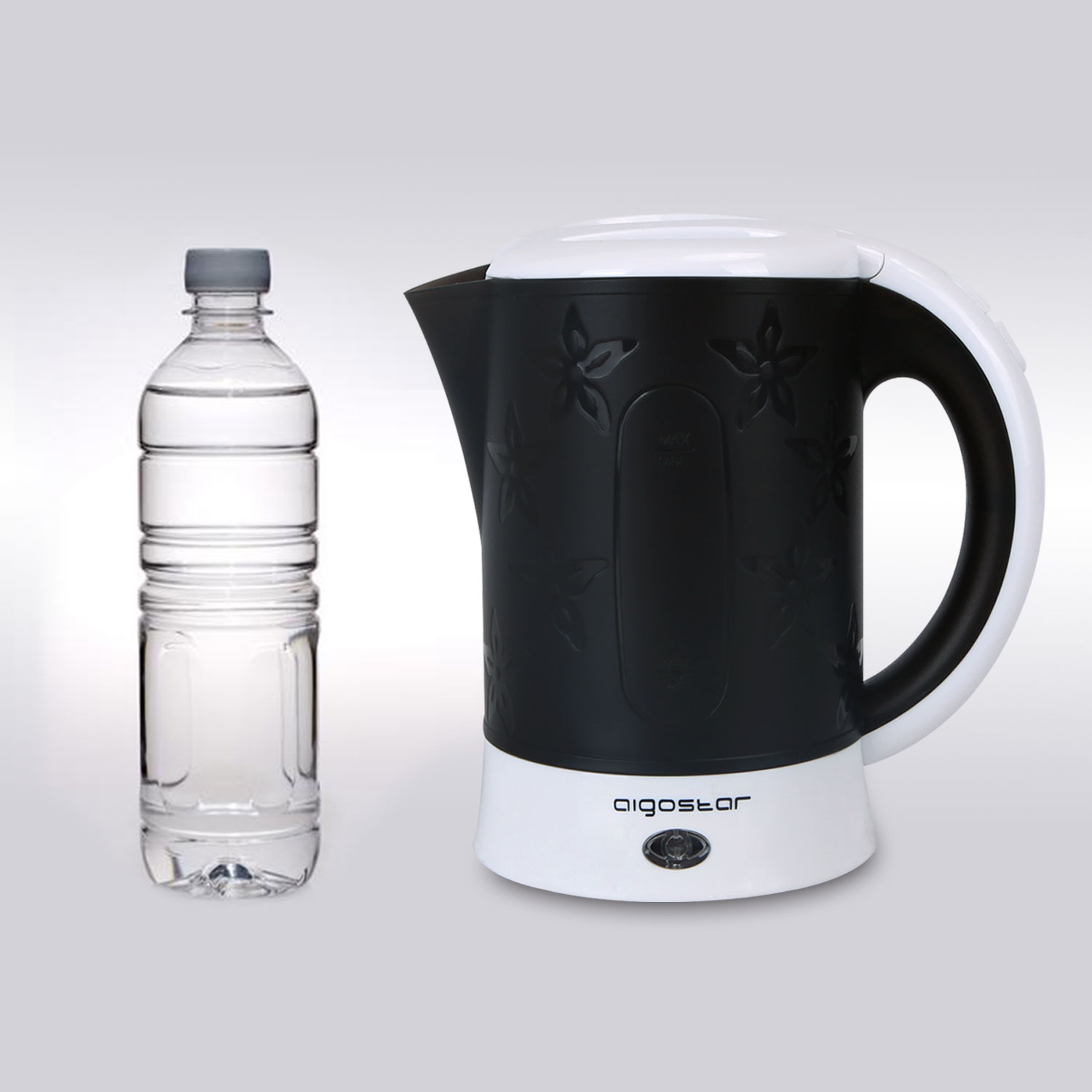 Hervidor eléctrico blanco y negro con botella de agua junto a él sobre superficie blanca.