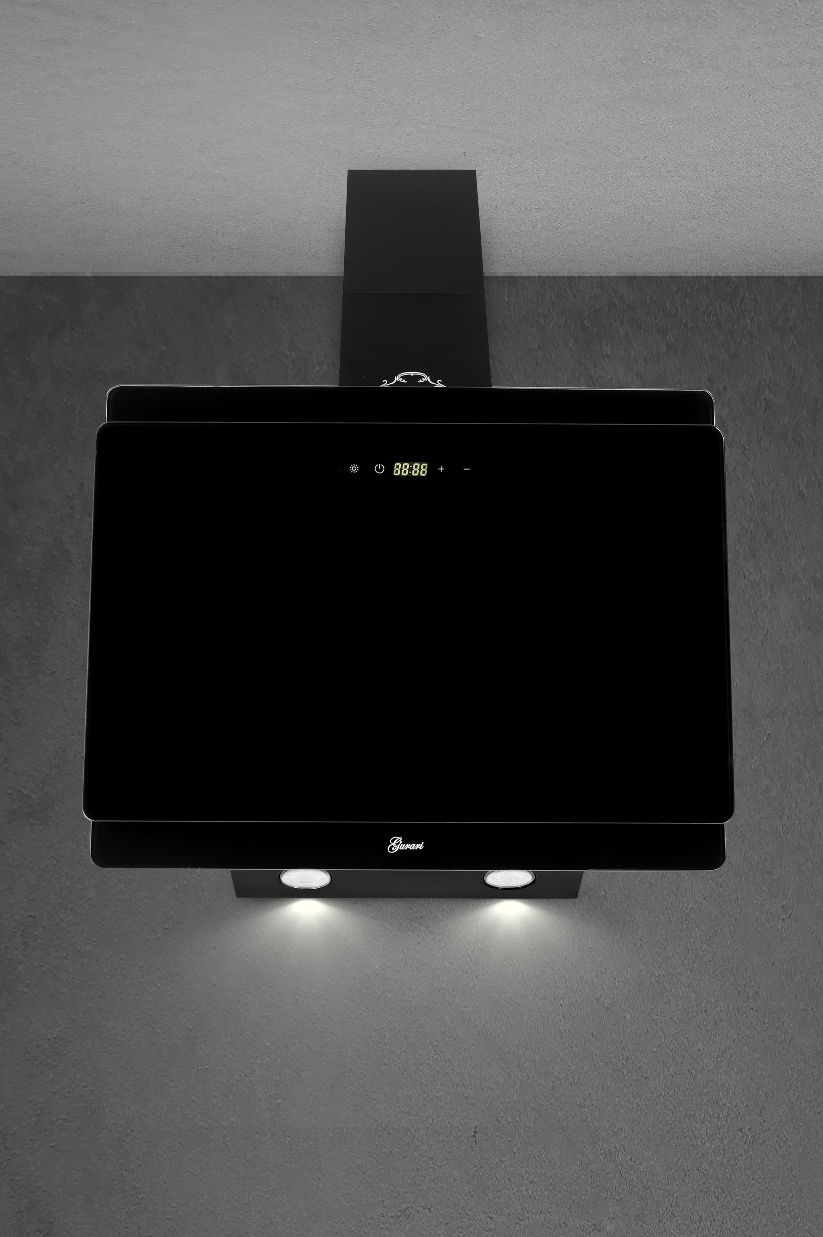 Schwarze Dunstabzugshaube mit Digitalanzeige und zwei Lichtern. Der Hintergrund ist eine graue Wand.