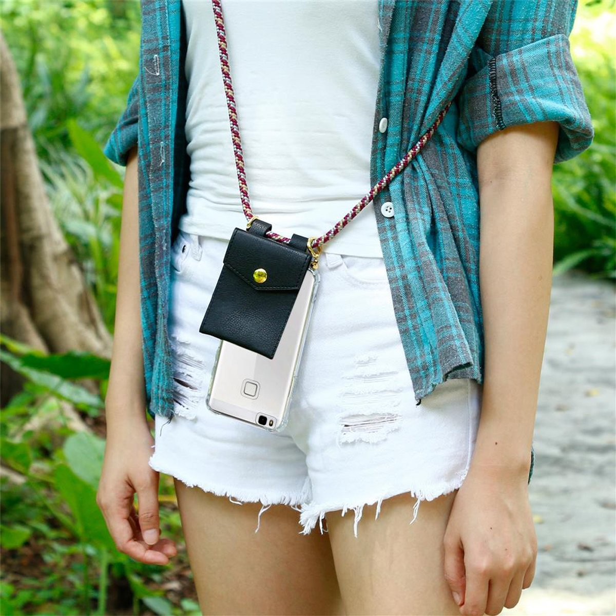 Eine Frau mit kariertem Hemd und Shorts, hält ein Telefon mit Hülle und Lanyard.