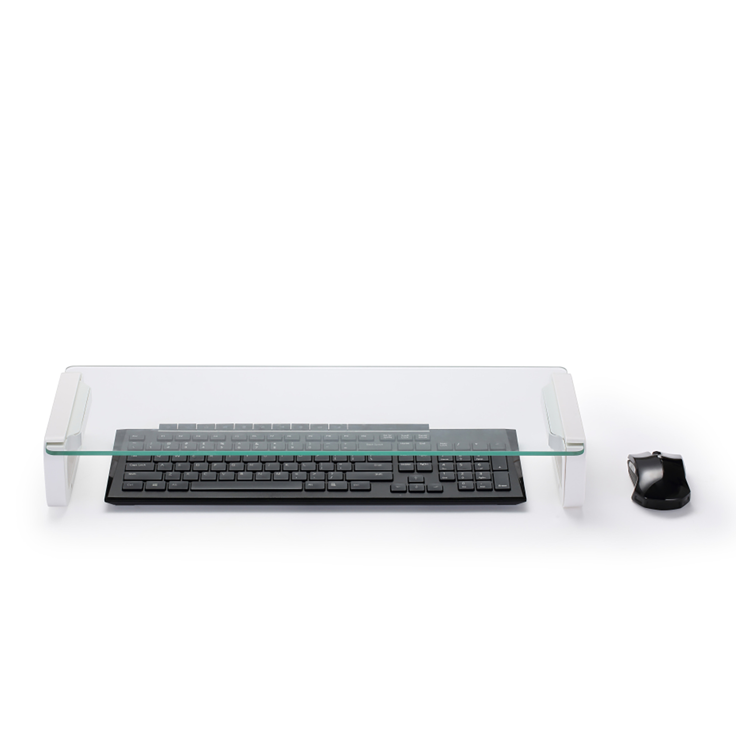 Eine Tastatur und Maus auf einem Glasständer auf weißer Oberfläche. Die Tastatur ist schwarz.