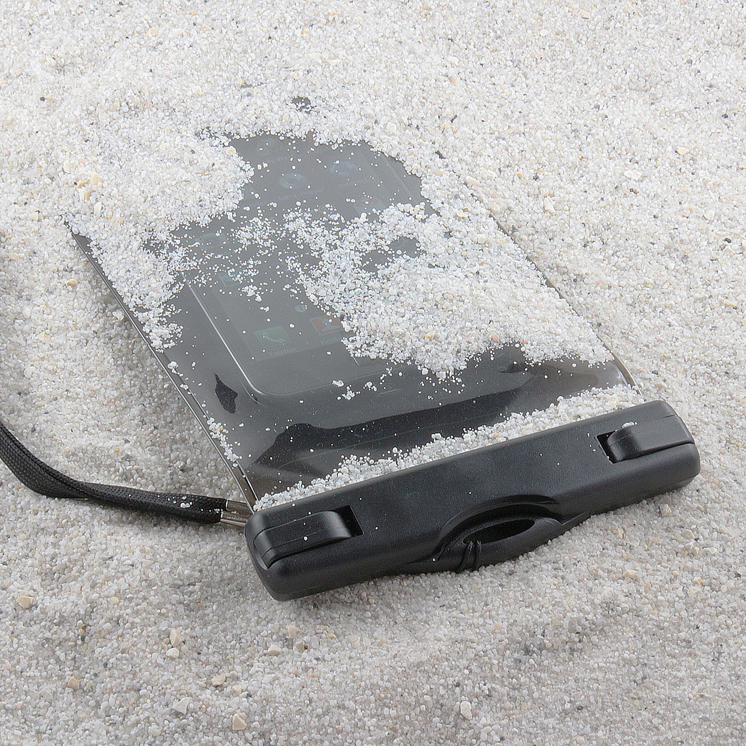 Eine schwarze wasserdichte Handytasche liegt auf Sand. Das Telefon im Inneren ist sichtbar.