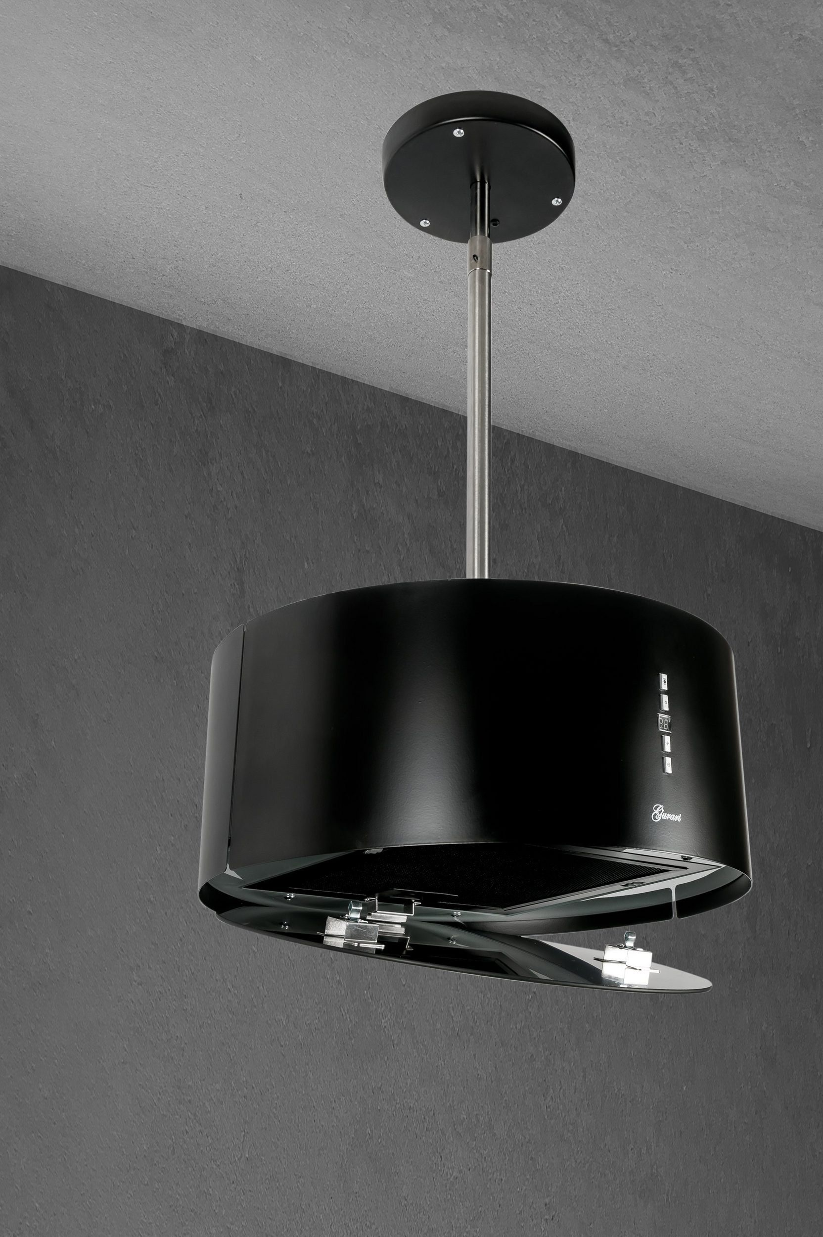 Campana extractora negra que cuelga del techo. Tiene un diseño curvo. Fondo gris.