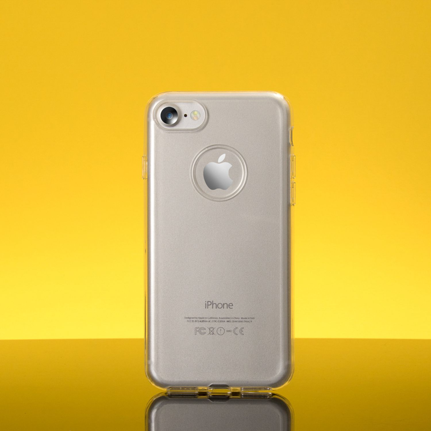 Silbernes iPhone mit transparenter Hülle auf gelbem Hintergrund. Apple-Logo sichtbar.