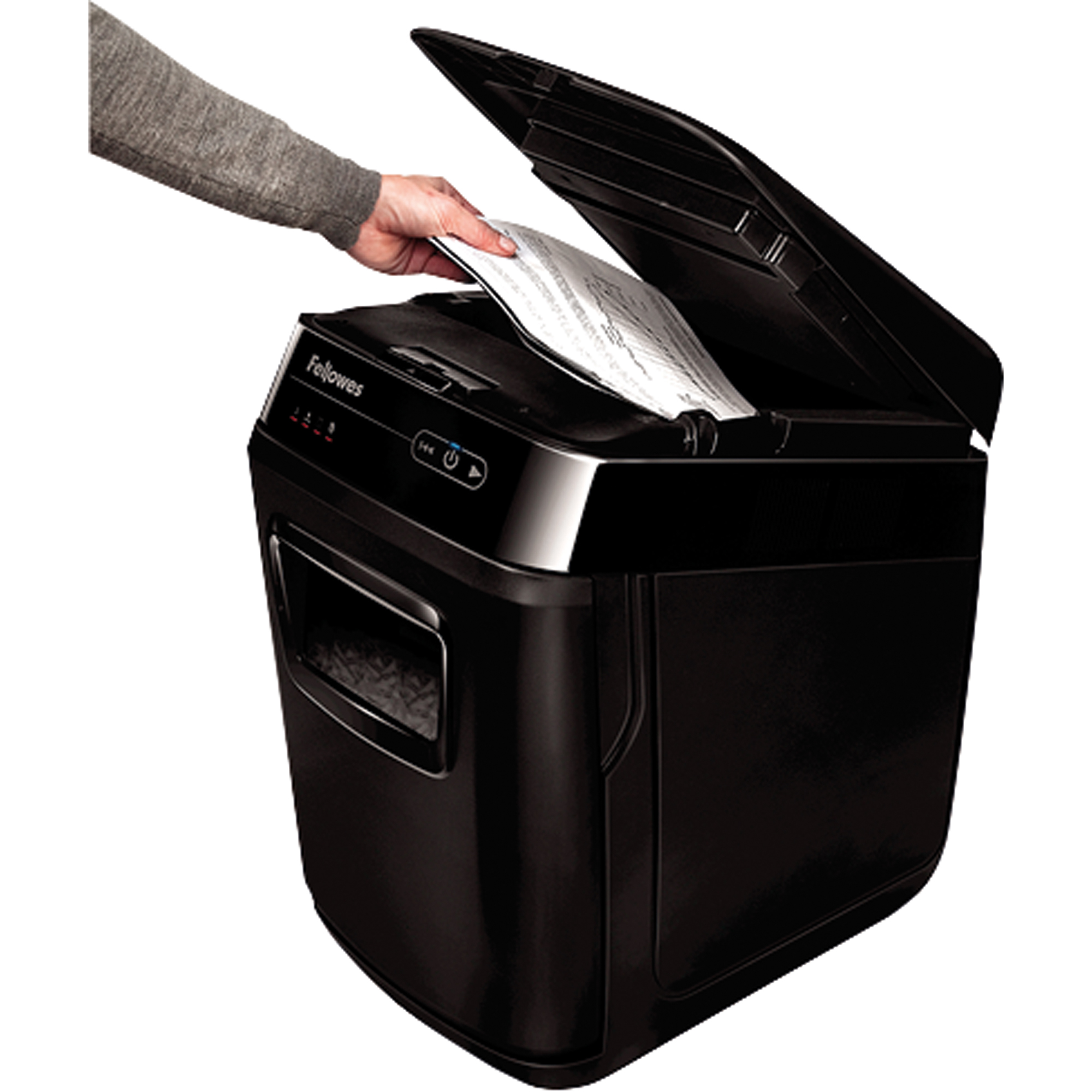 Osoba wkłada kartkę papieru do czarnej niszczarki z otwartą pokrywą.