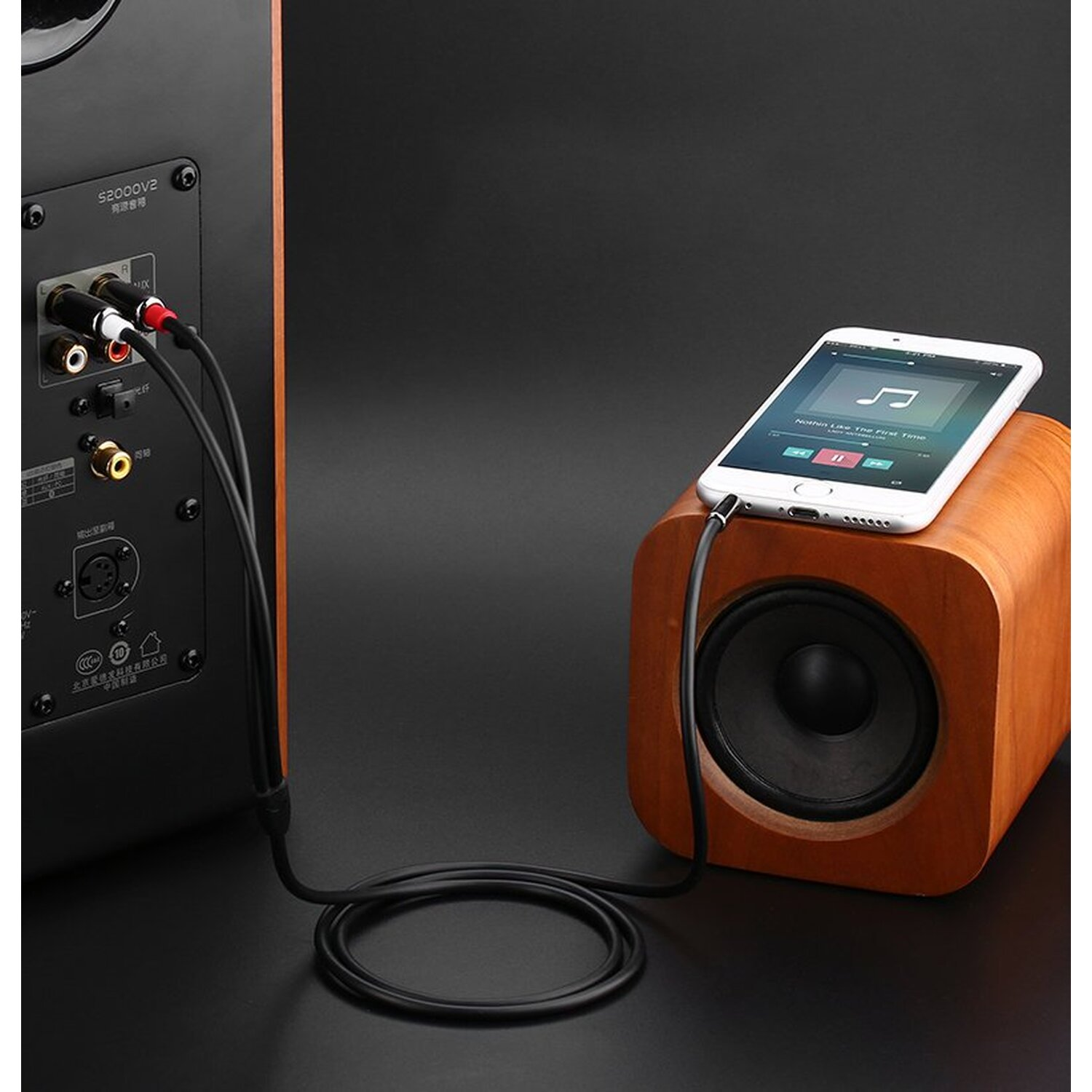 Lautsprecher und Telefon mit Kabeln verbunden. Musikoberfläche auf dem Telefonbildschirm.