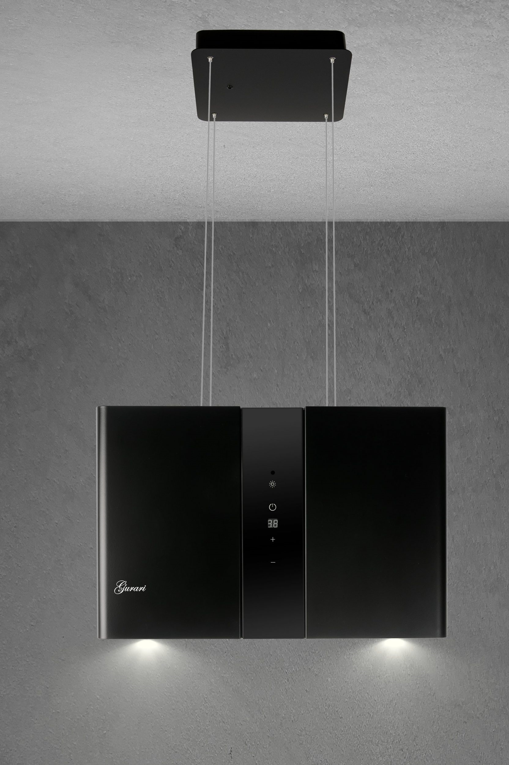 Schwarze Dunstabzugshaube, die von der Decke hängt, mit Lichtern unten und einem dunkelgrauen Hintergrund.