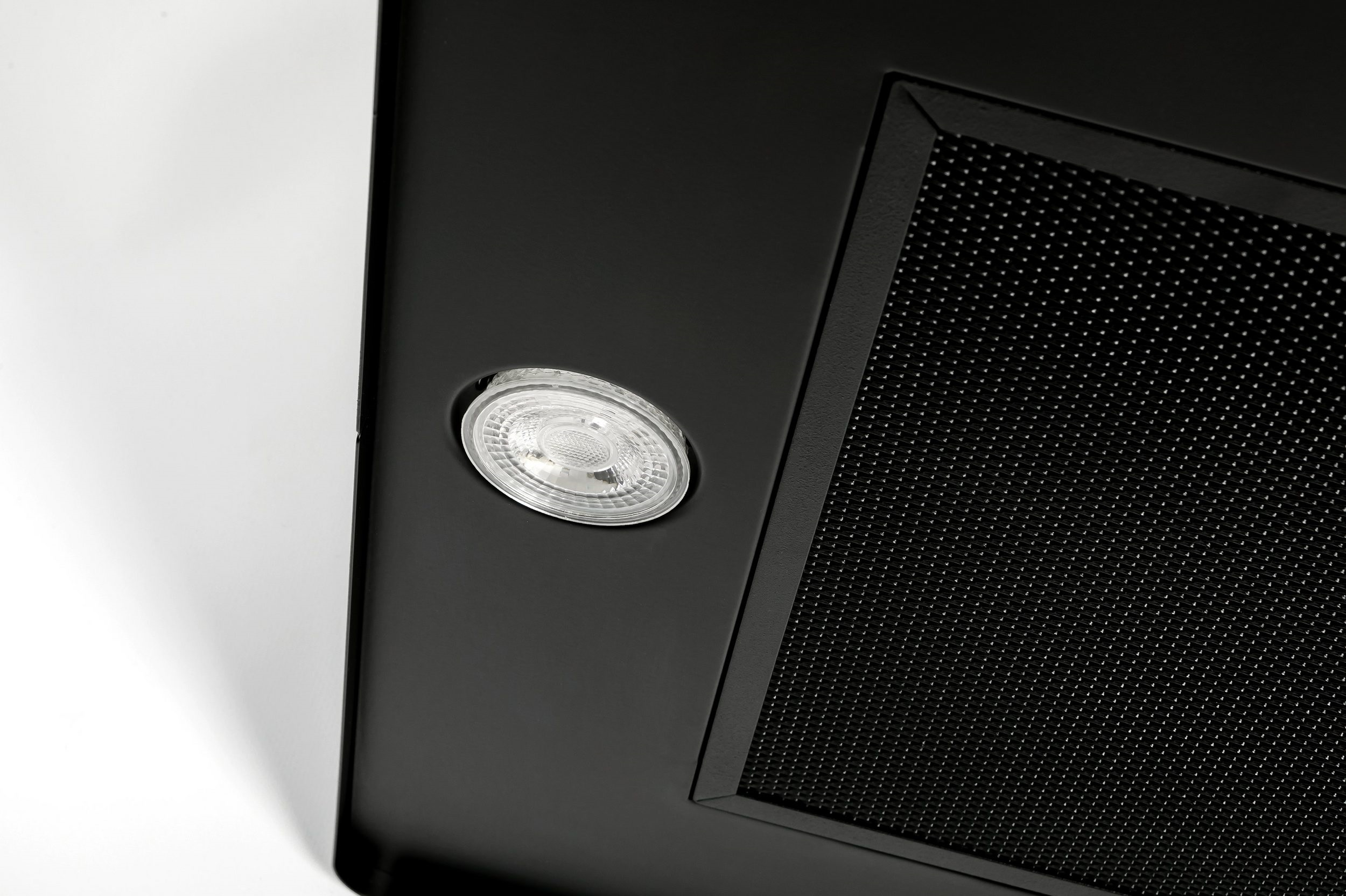 Schwarze Dunstabzugshaube mit Licht und Metallgitter.