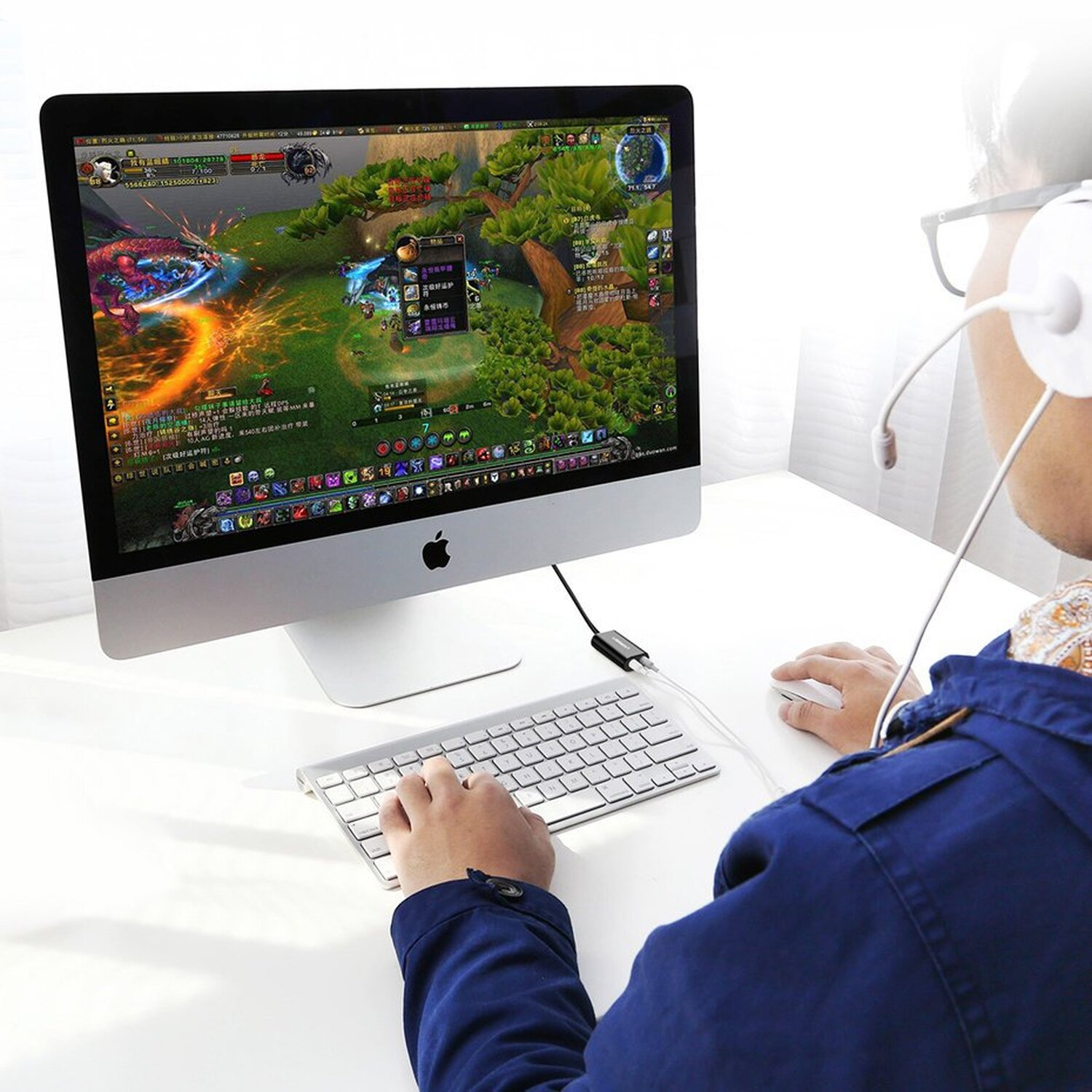 Osoba grająca w grę na komputerze. Ekran wyświetla scenę z gry wideo, ma na sobie słuchawki.