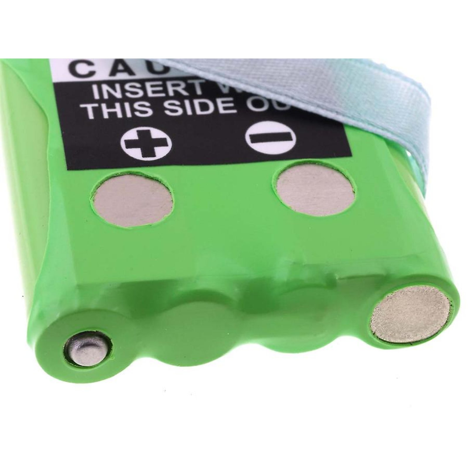 Una batería verde con una etiqueta de advertencia en blanco y negro. Hay dos círculos de metal.