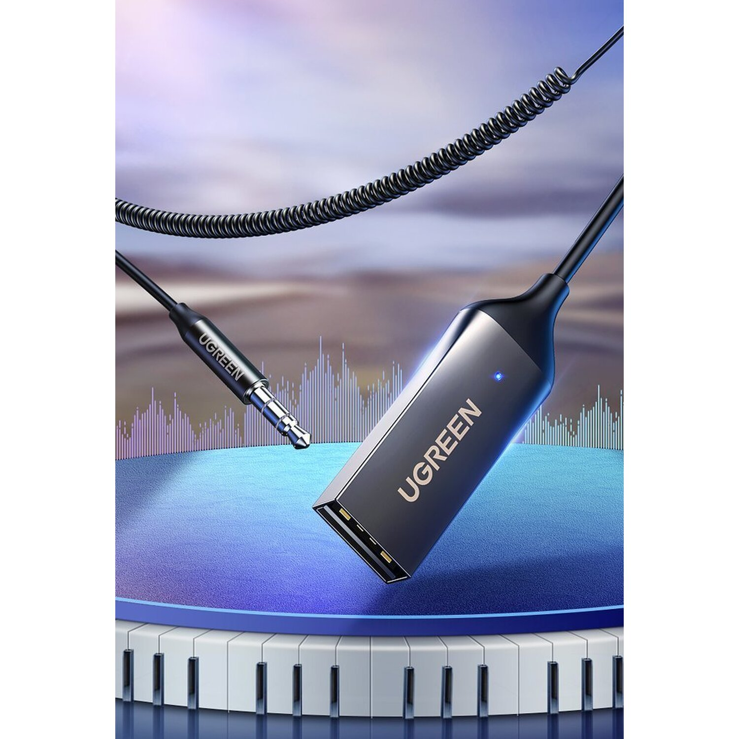 Czarny adapter UGREEN ze srebrnym złączem USB i gniazdem 3,5 mm. Niebieskie tło.