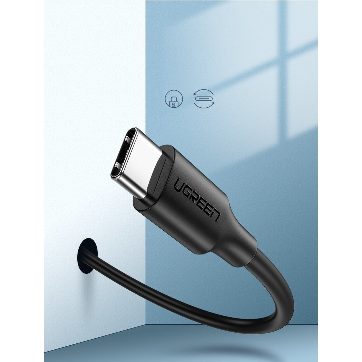 Czarny kabel USB-C UGREEN podłączony do gniazdka ściennego. Widoczny symbol kłódki i strzałki.