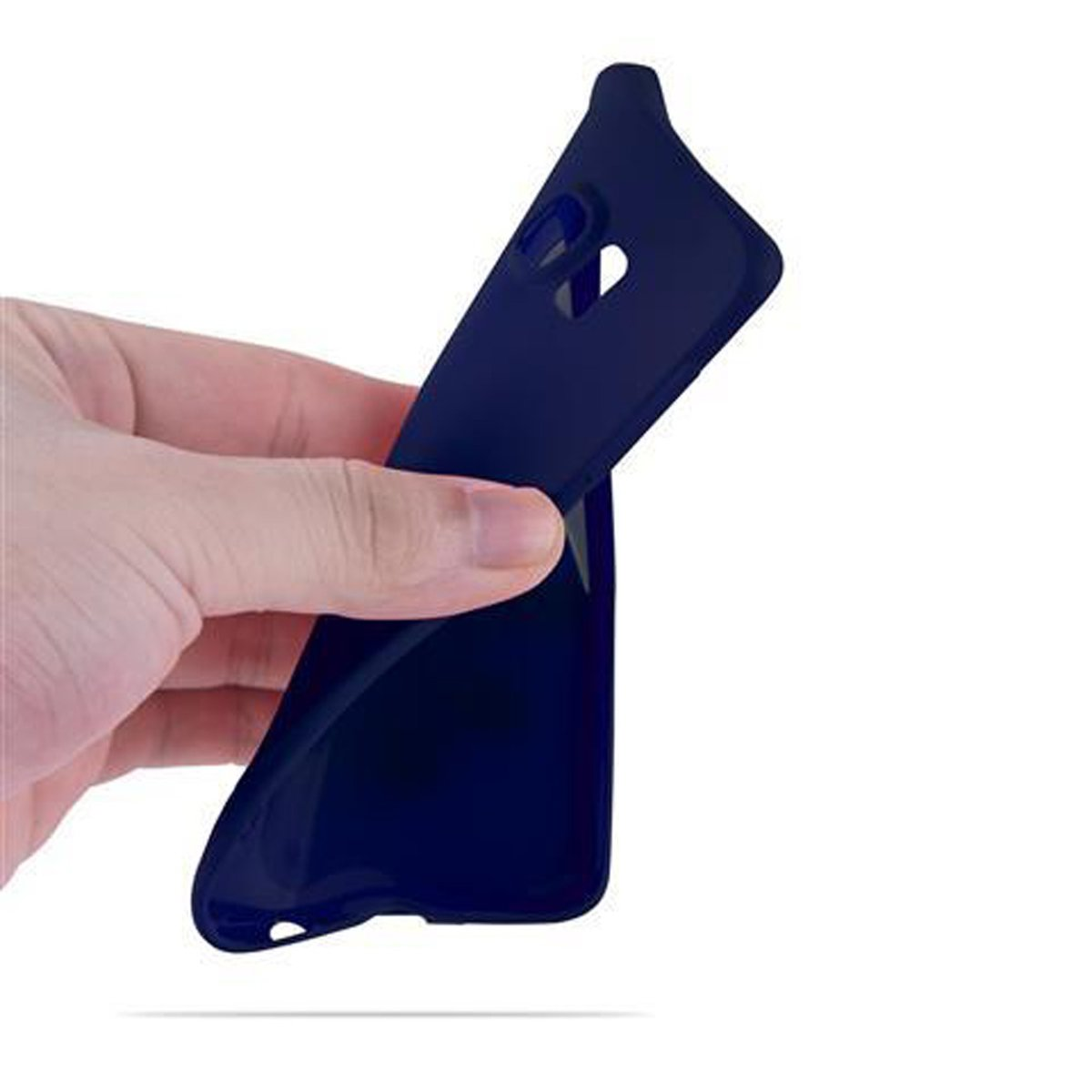Una mano che tiene e piega una custodia blu navy, isolata su bianco.