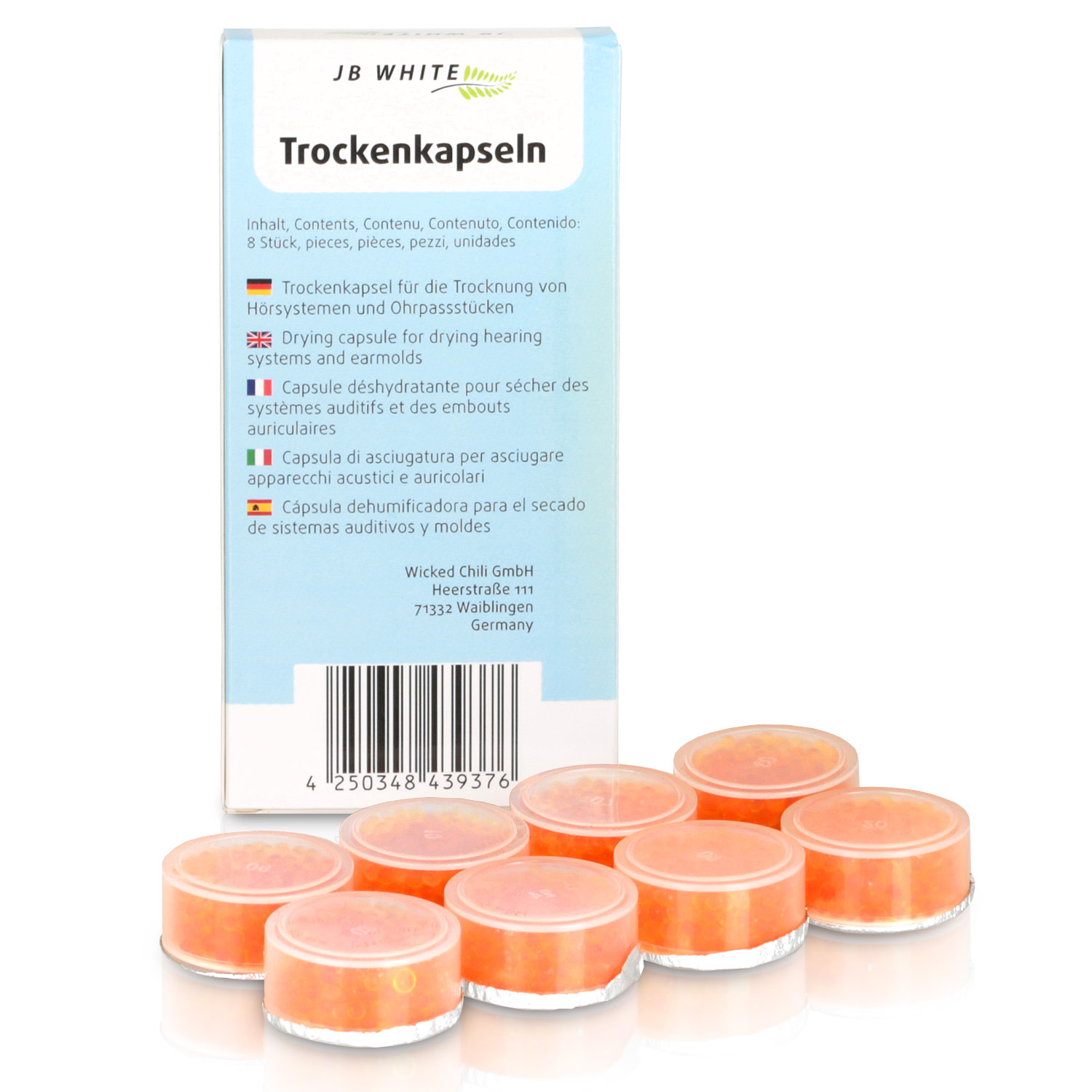 Schachtel mit Trocknungskapseln und darunter orangefarbene Kapseln. Text in mehreren Sprachen.