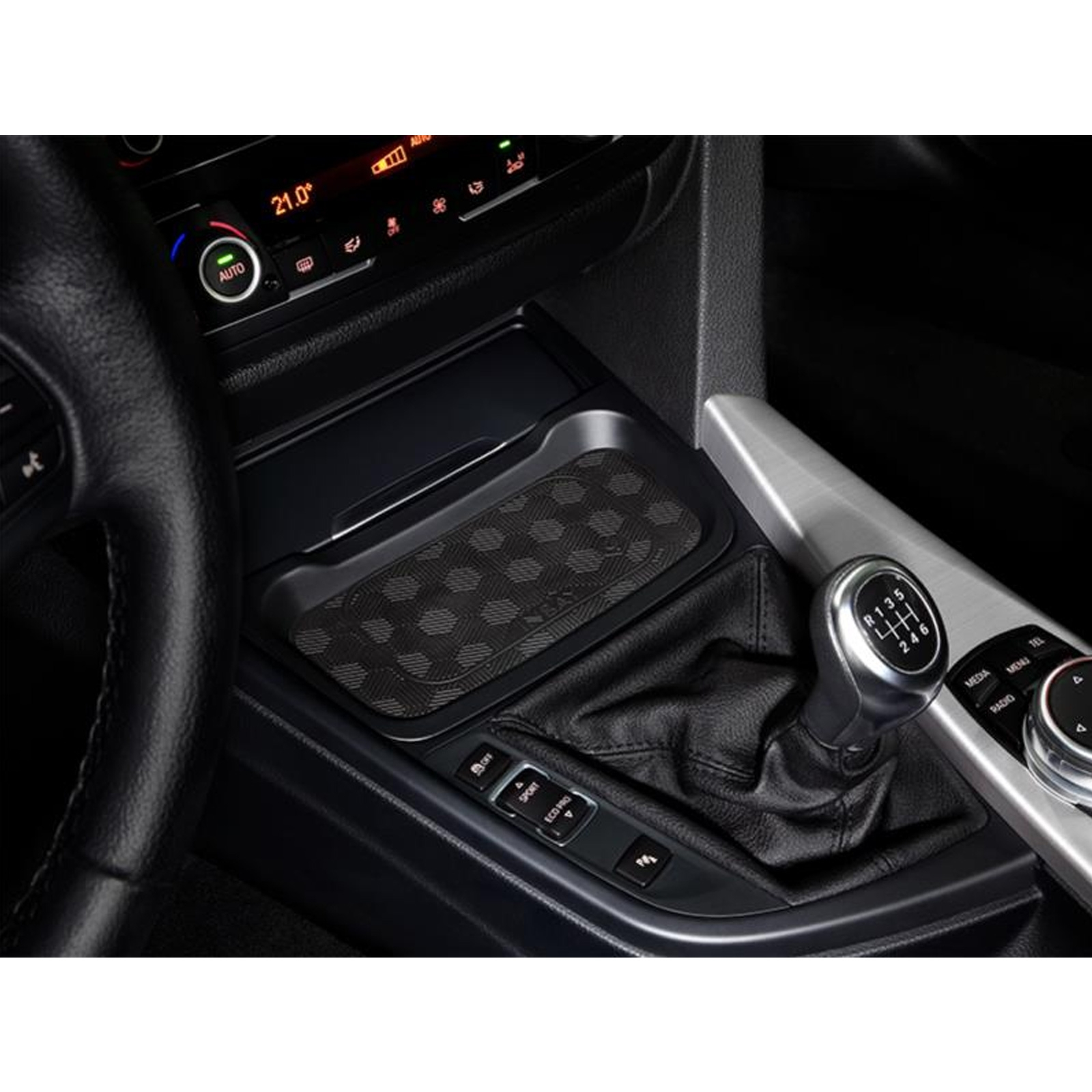Schwarze Autokonsole mit Ablagefach und Schalthebel. Silber- und schwarze Verkleidung.