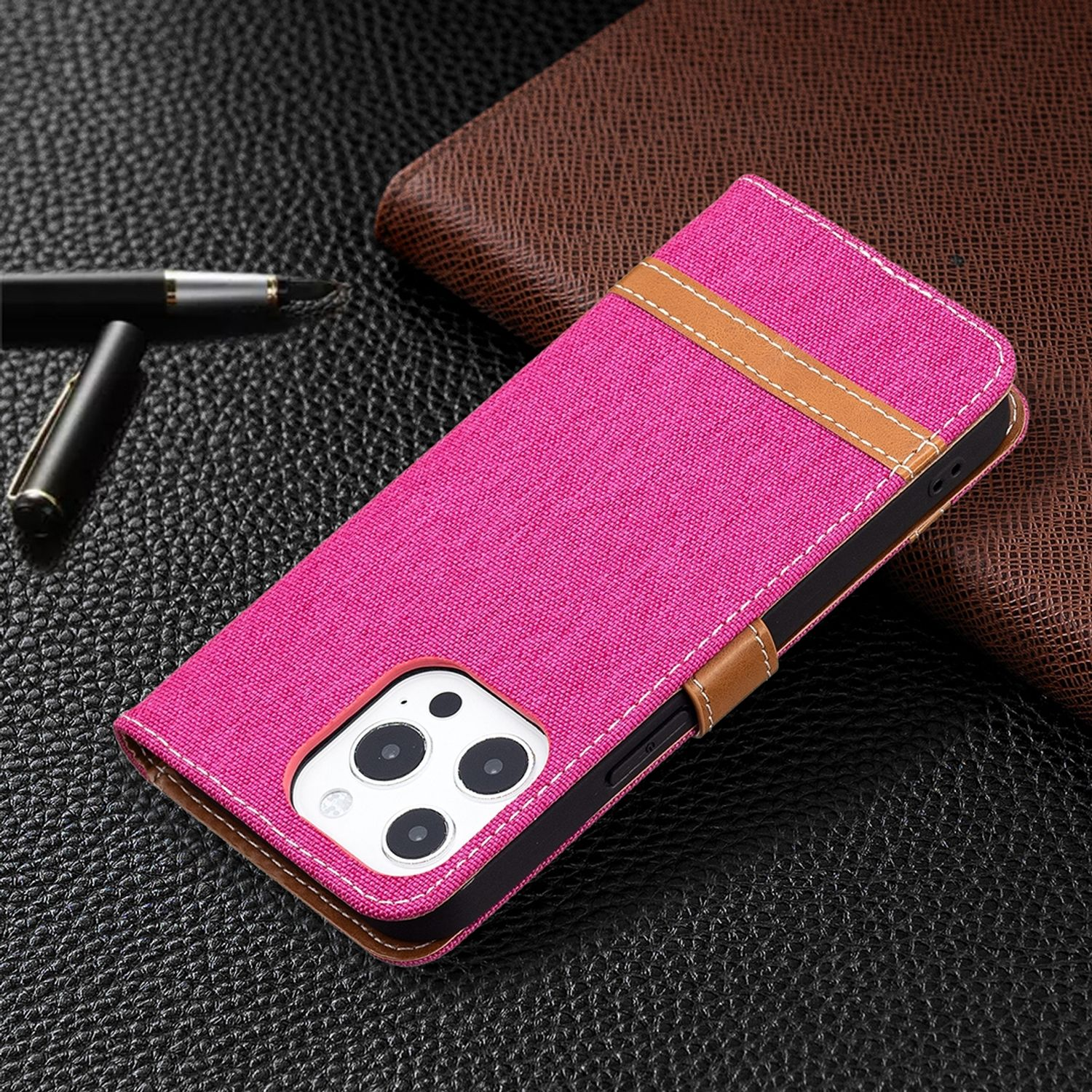 Eine pinke Handyhülle mit braunem Streifen und Telefon auf dunkler Oberfläche.
