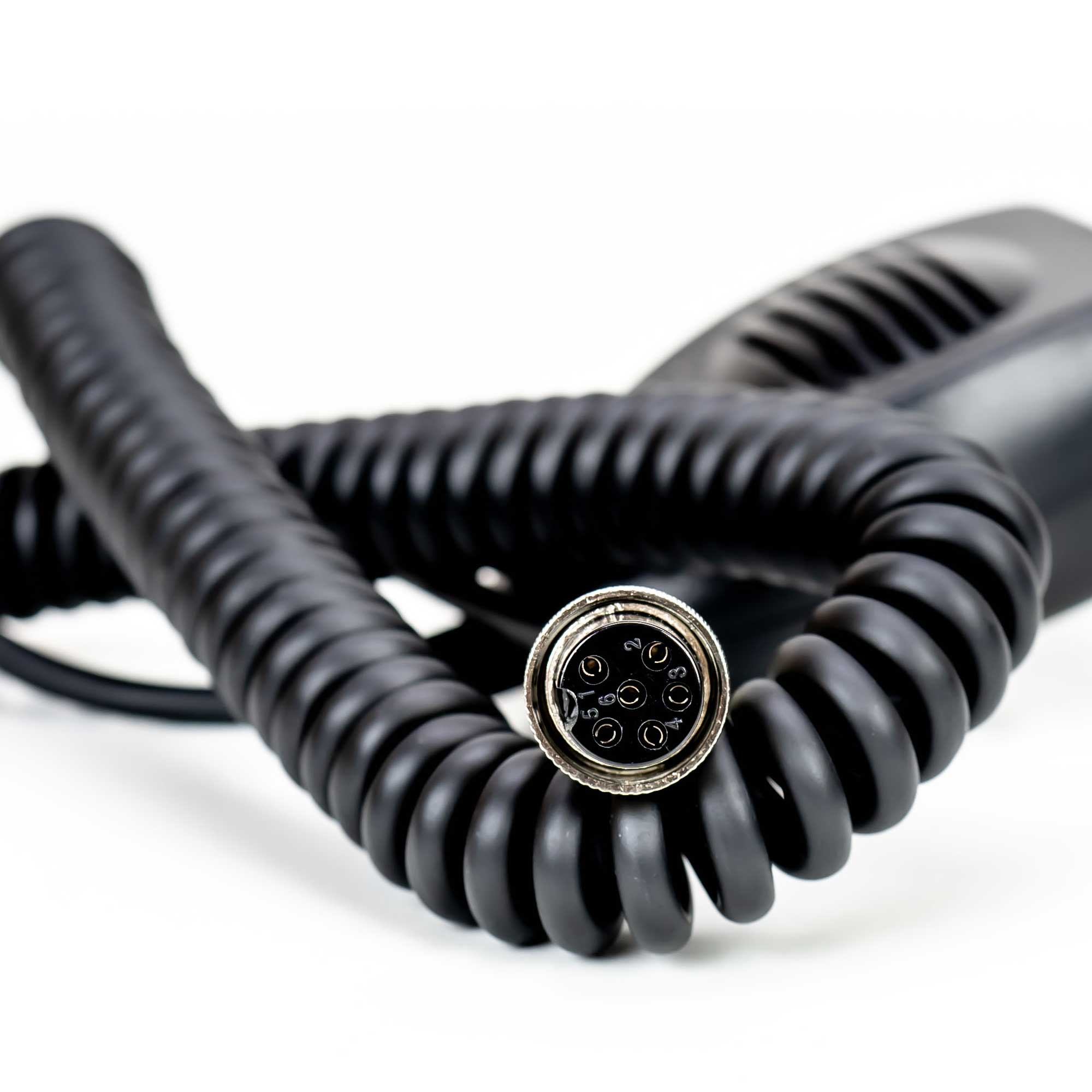 Cavo nero riccio con un connettore. Il connettore ha sette fori. Sfondo bianco.