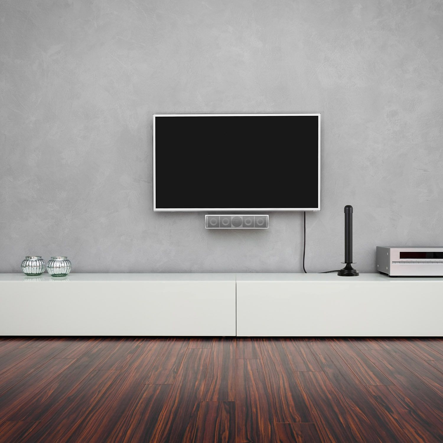 Ein Fernseher an der Wand über einem weißen Schrank. Holzboden im Vordergrund.
