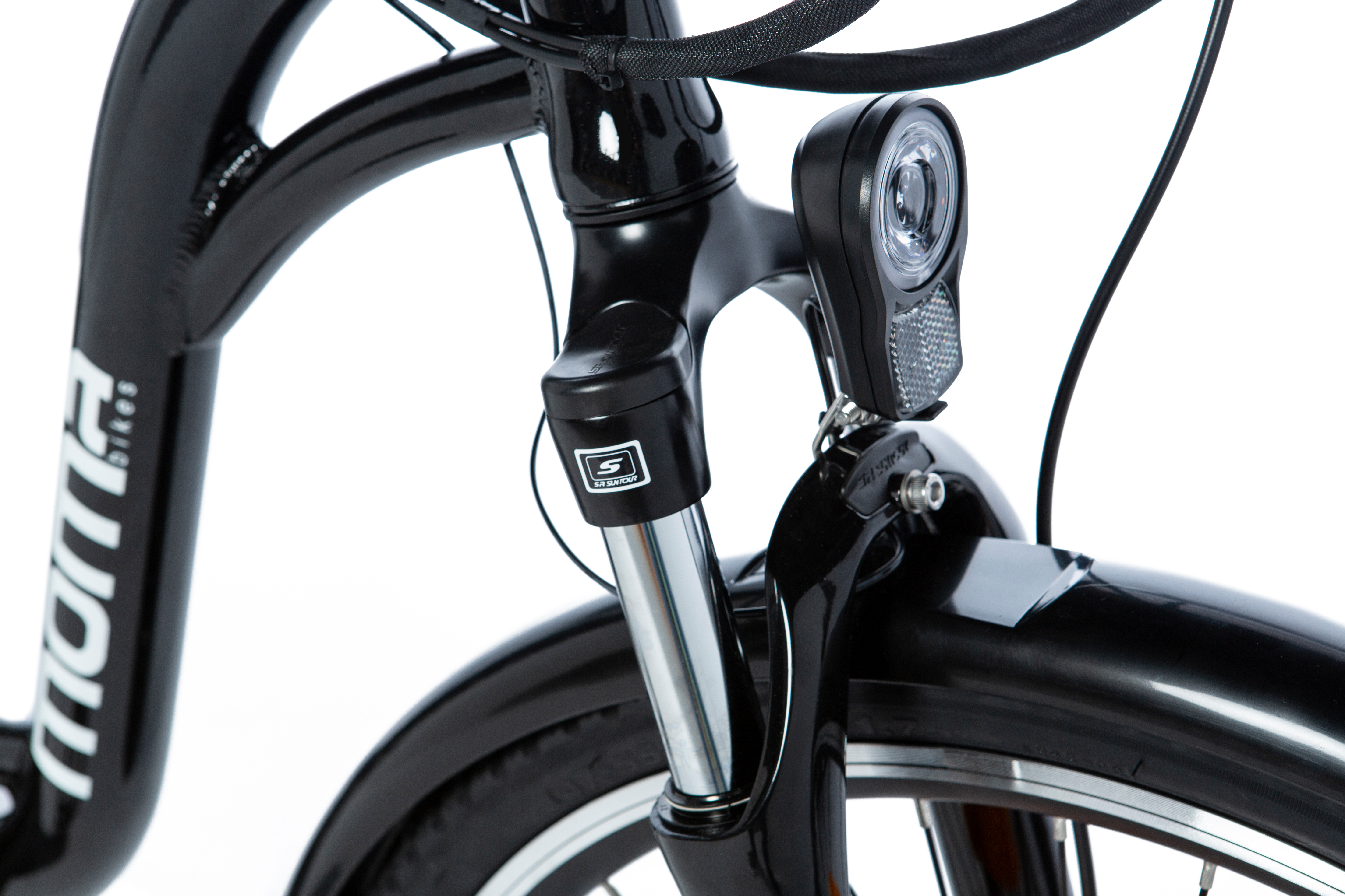 Primo piano della forcella di una bicicletta nera. Faro, pneumatico anteriore e parafango visibili.