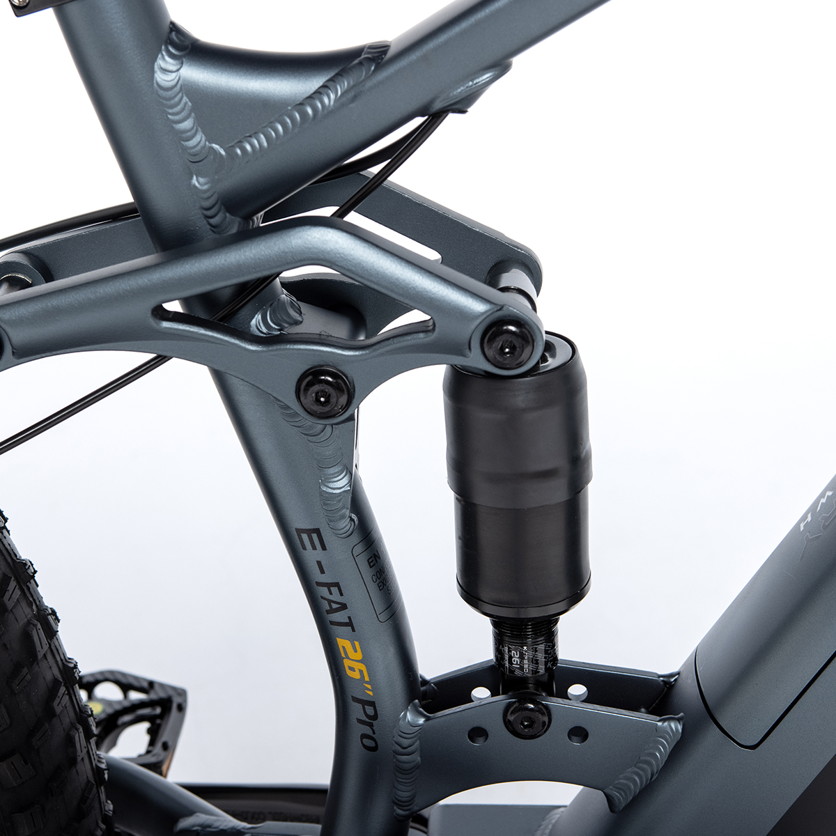 Primer plano del sistema de suspensión de una bicicleta. Color gris, amortiguador negro.