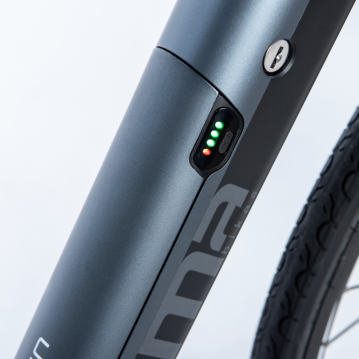 Primo piano di una batteria e-bike nera con indicatore di carica. Luci verdi e rosse.