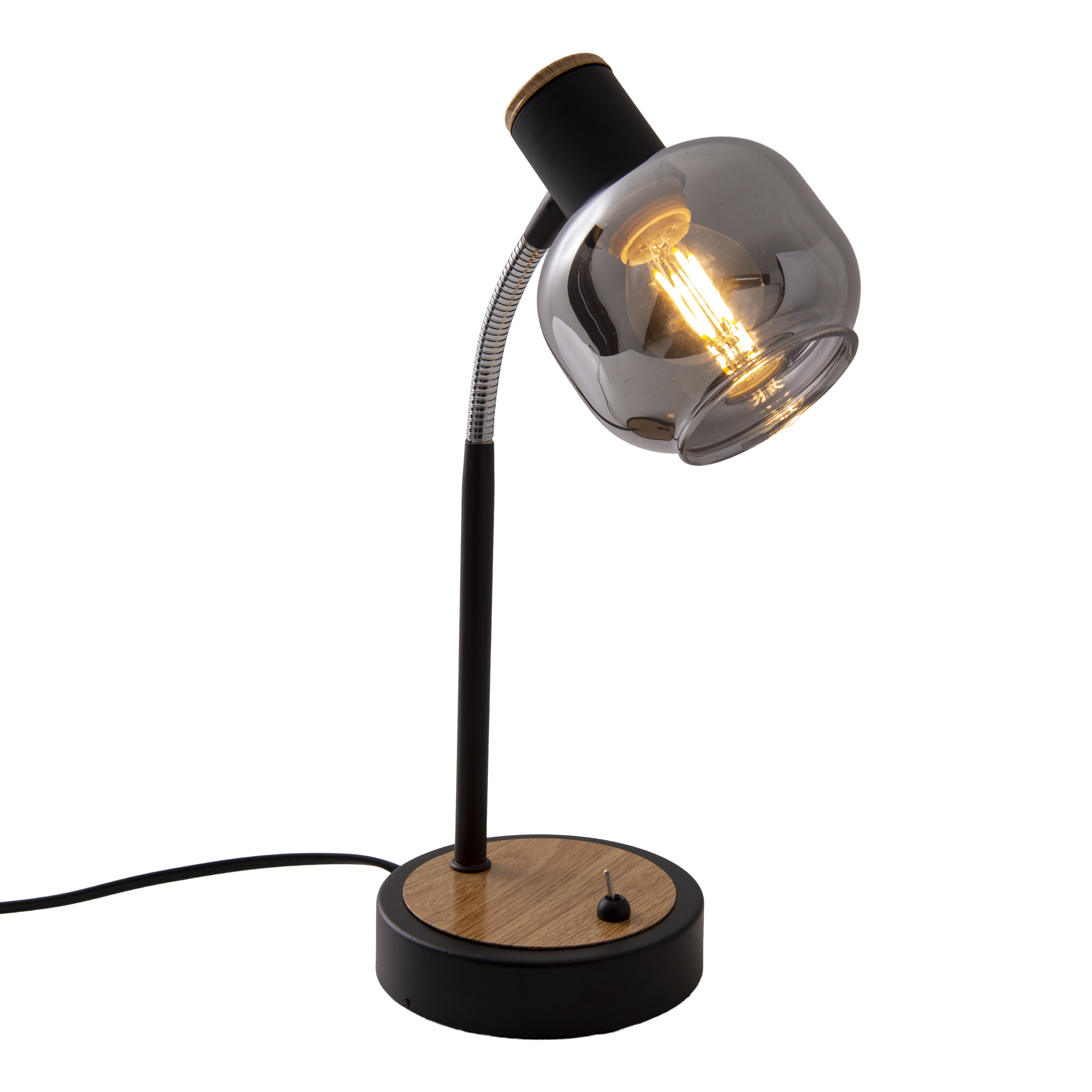 Una lampada da scrivania con base nera, braccio curvo e paralume in vetro fumé con lampadina visibile.