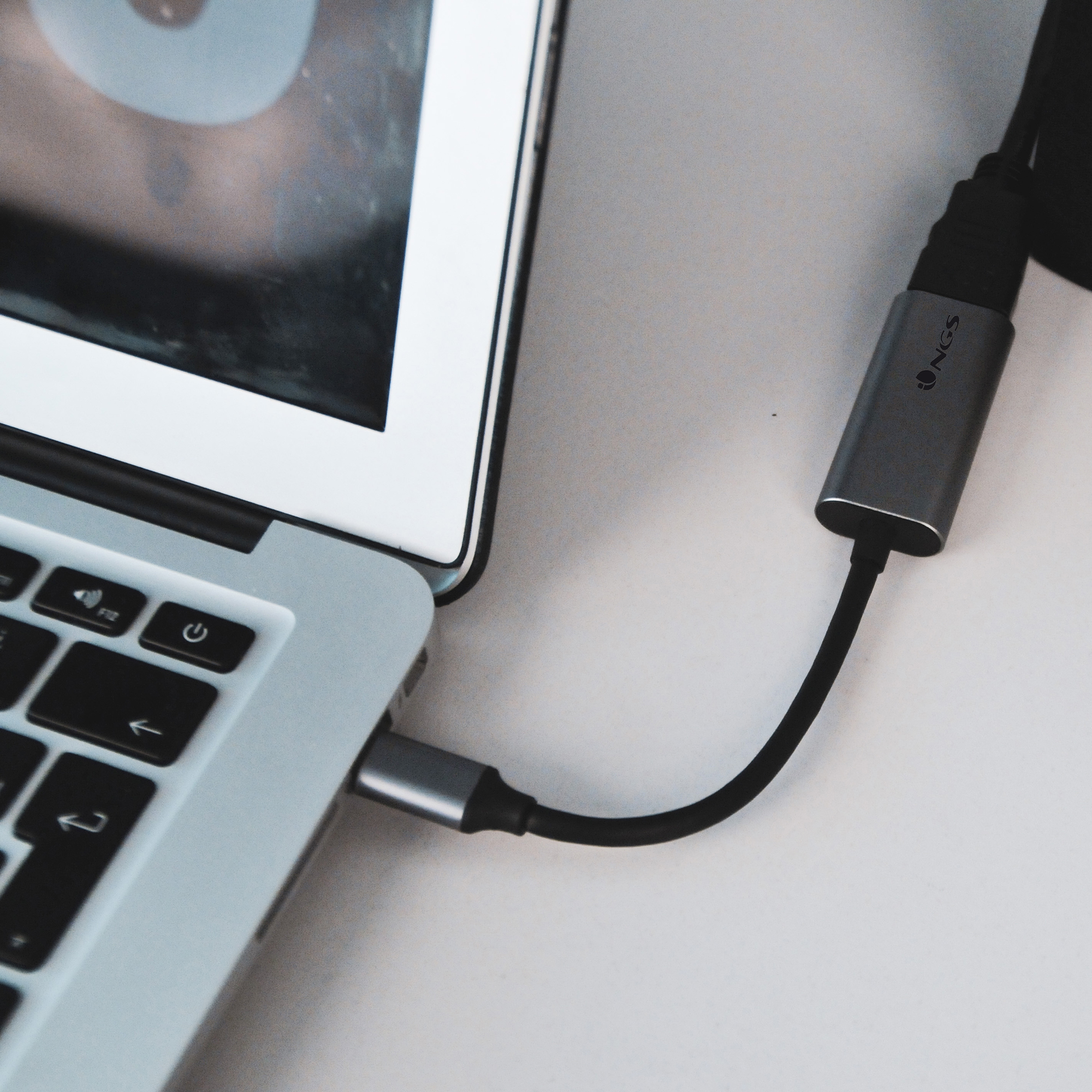 Portátil con un adaptador conectado. El adaptador está conectado a un cable negro.
