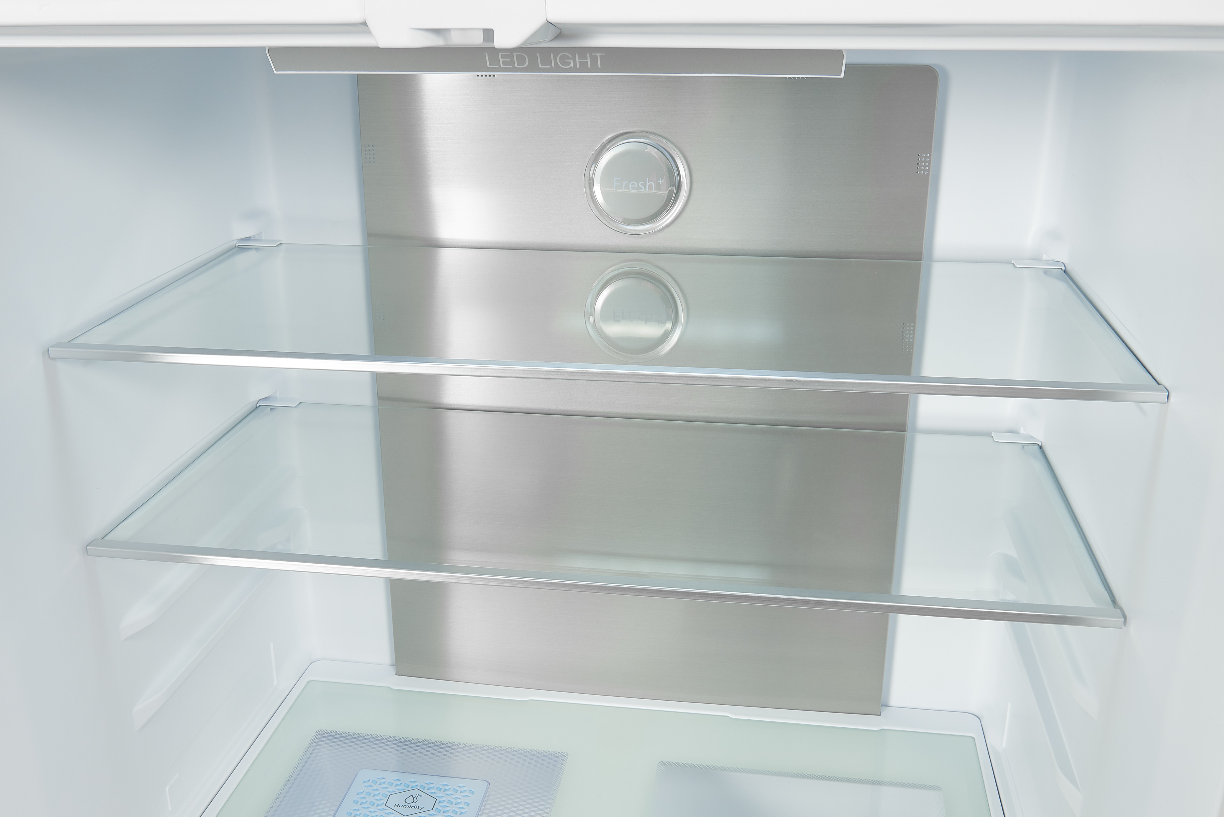 Innenraum eines Kühlschranks mit Glasböden. Zwei Glasböden und eine Metallrückwand.