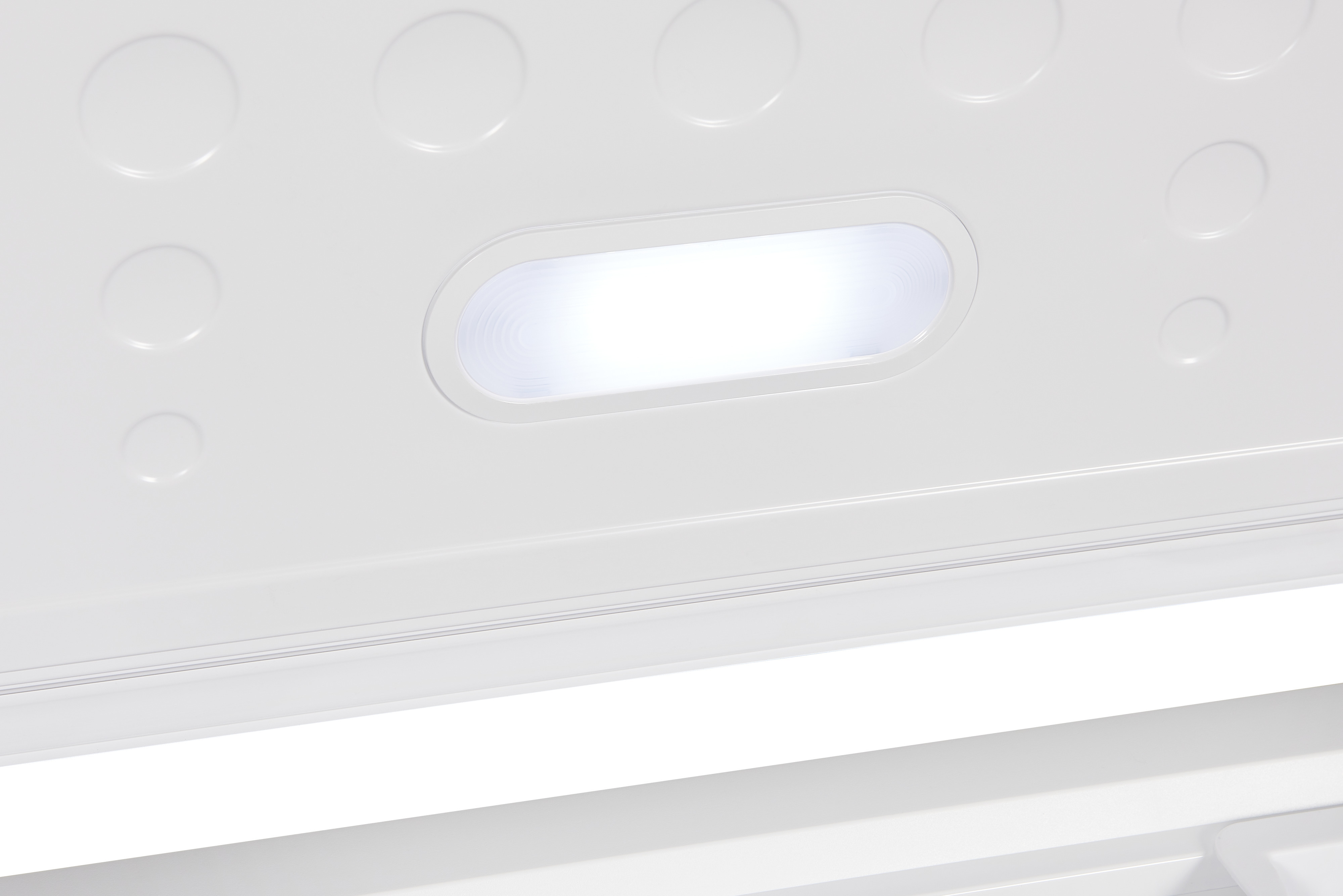 Nahaufnahme eines weißen Kühlschrankinnenraums mit hellem Licht.
