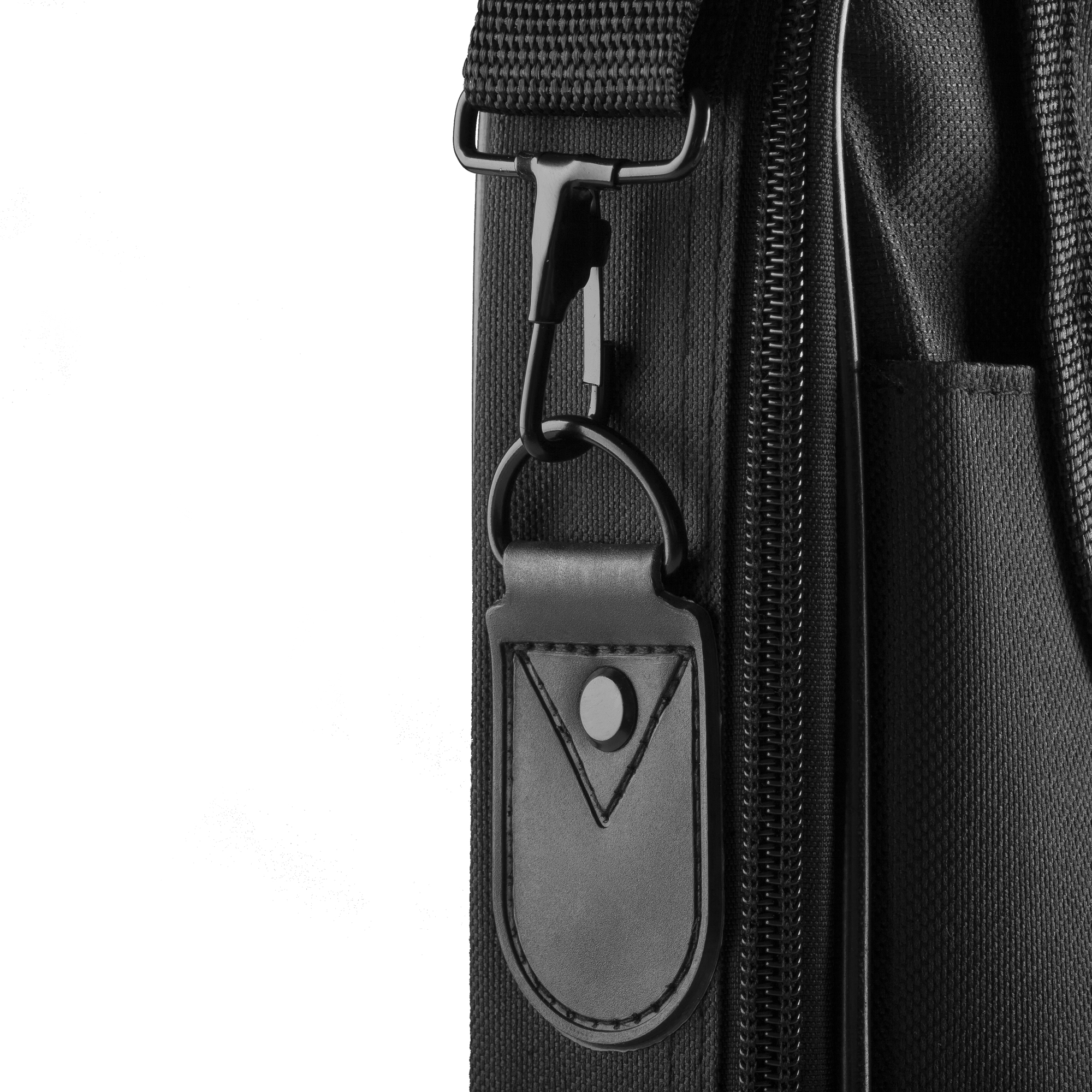 Cinturino nero con gancio in metallo su borsa nera, sfondo nero, ripresa ravvicinata.